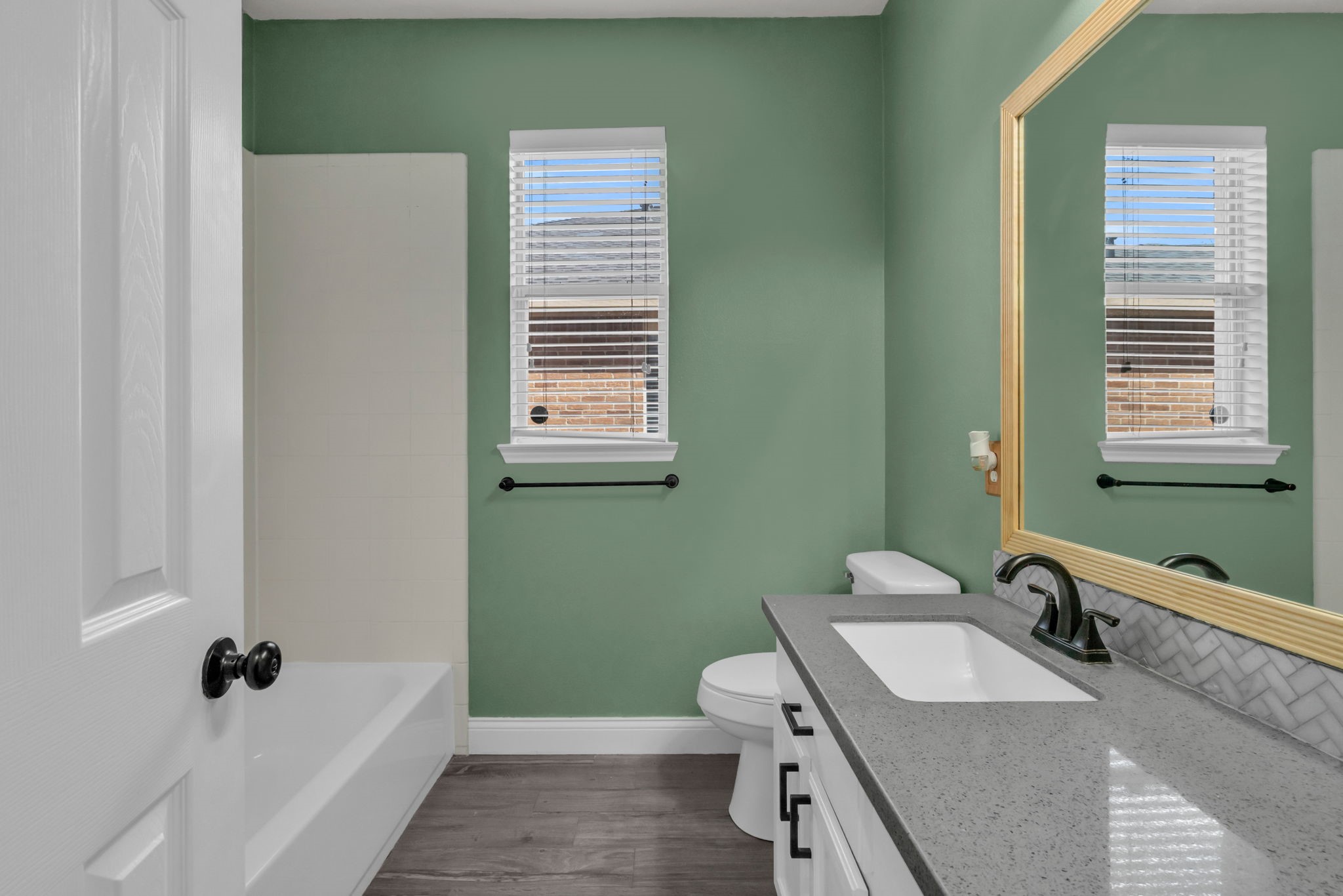 Secondary bathroom with a combination tub and shower.