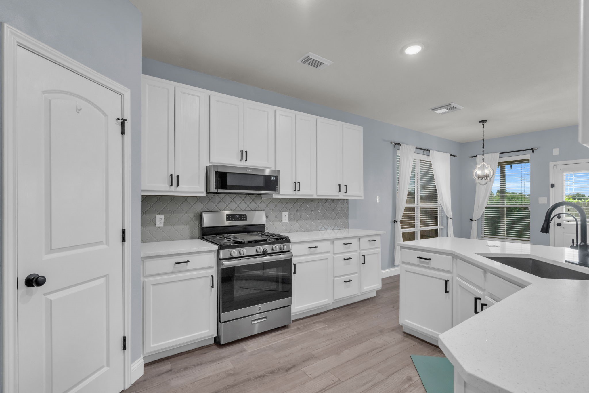 This updated kitchen is absolutely eye-catching with bright cabinets, new hardware, and a new faucet.
