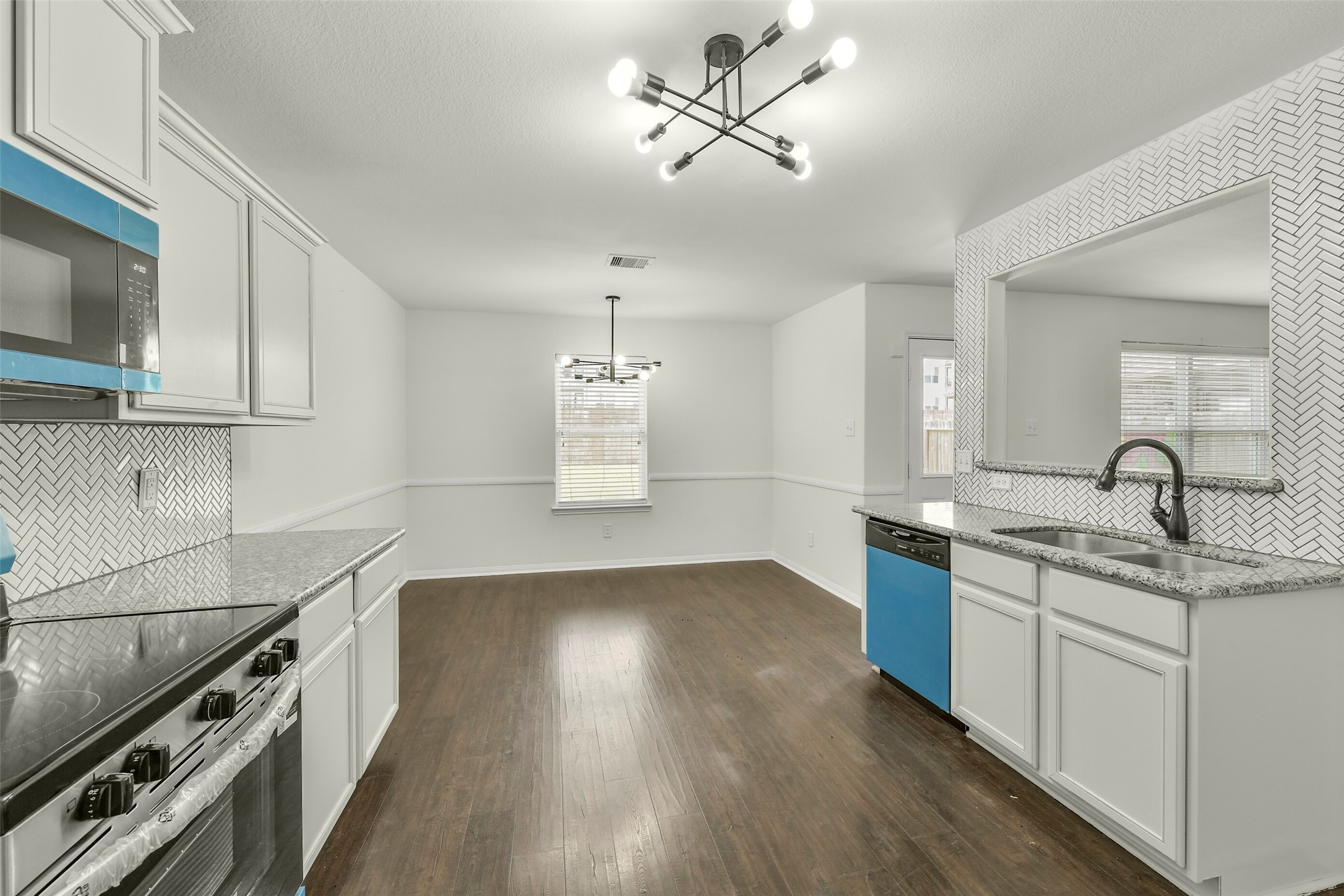 Modern kitchen with granite countertops, custom cabinetry, and updated appliances.