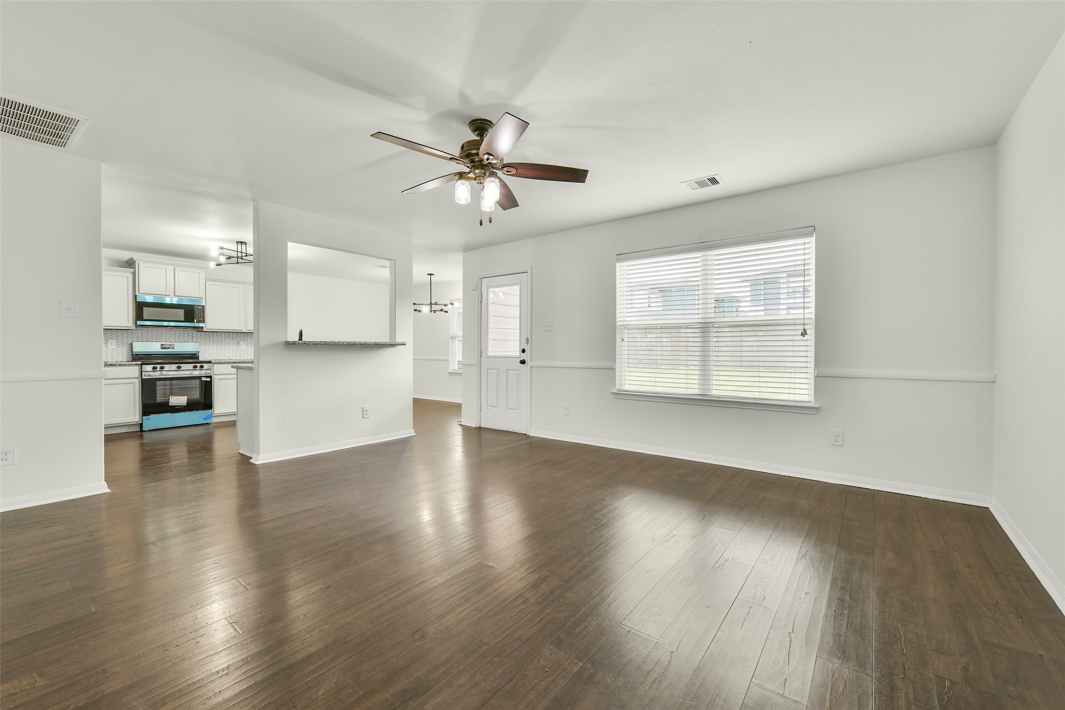 Open-concept living area with abundant natural light and seamless flow into dining and kitchen spaces.