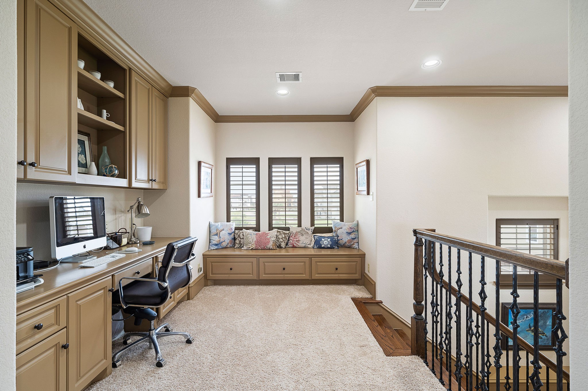 A cozy bench seating area adjacent to the open study provides a perfect spot for reading or relaxing in a quiet corner
