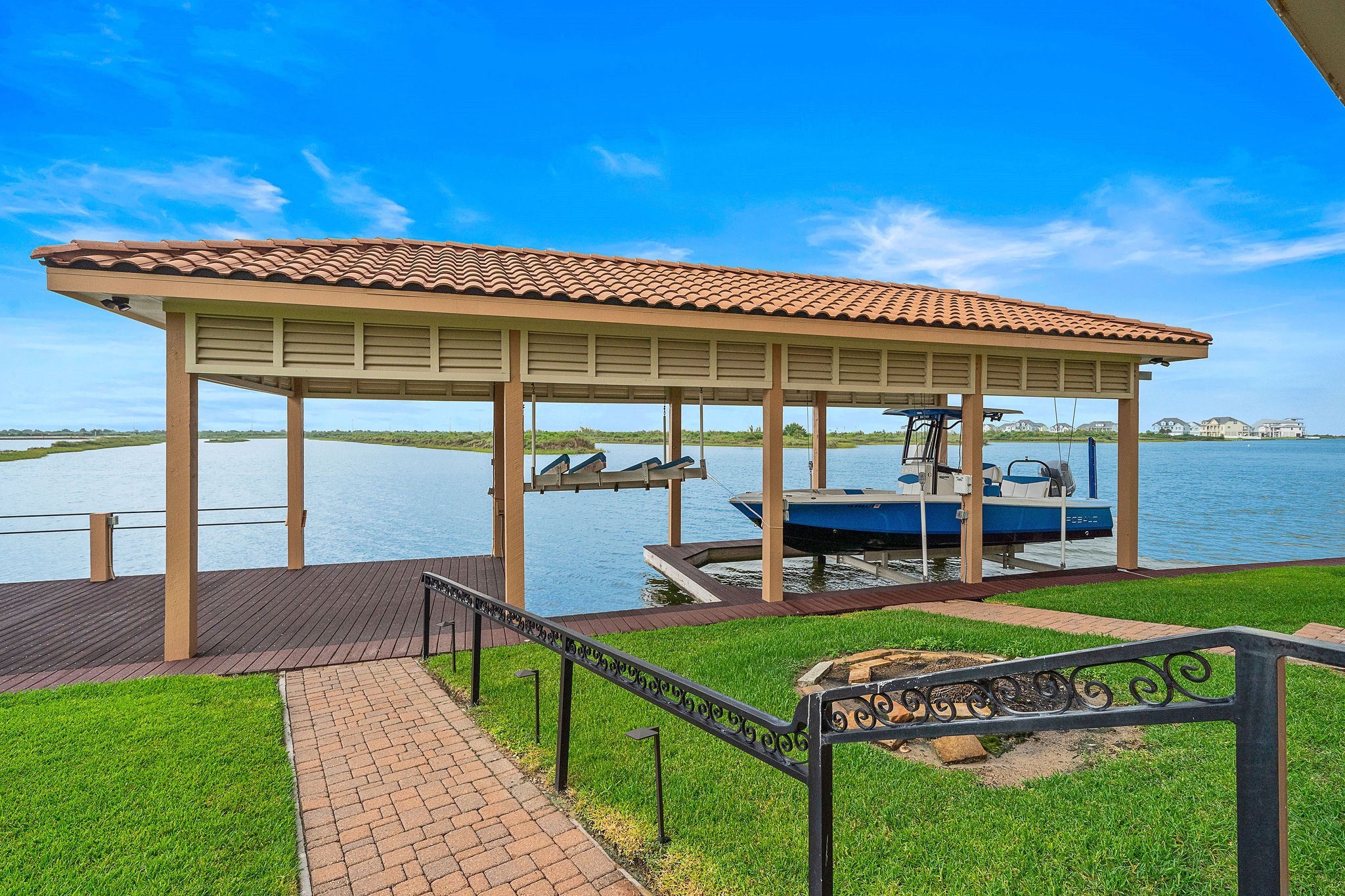 Follow the paver pathway to your large boathouse equipped with boat and jet ski lifts, along with dock space perfect for fishing, relaxing, and enjoying waterfront views