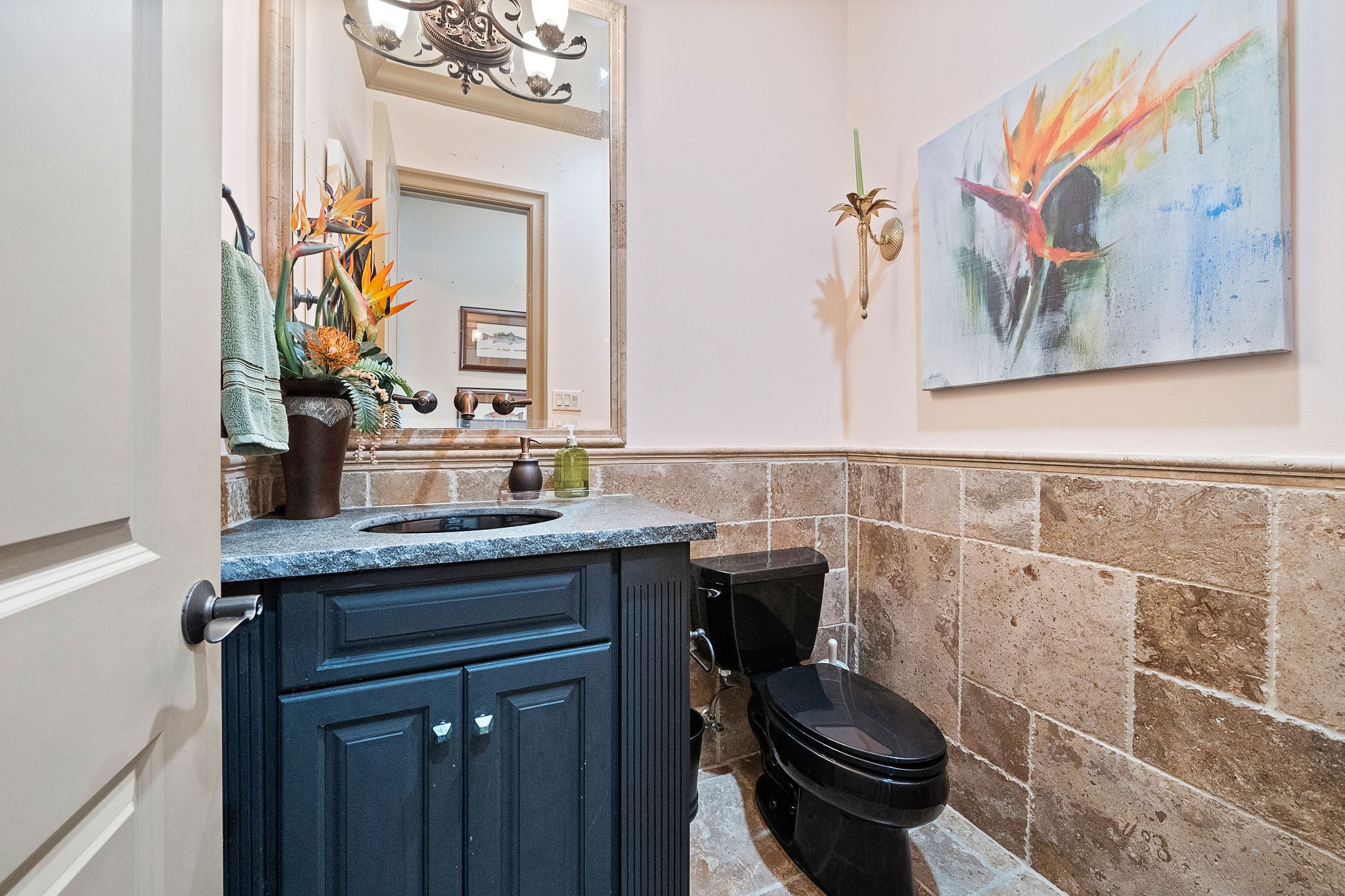 Powder room with travertine surround located on main level for convenience