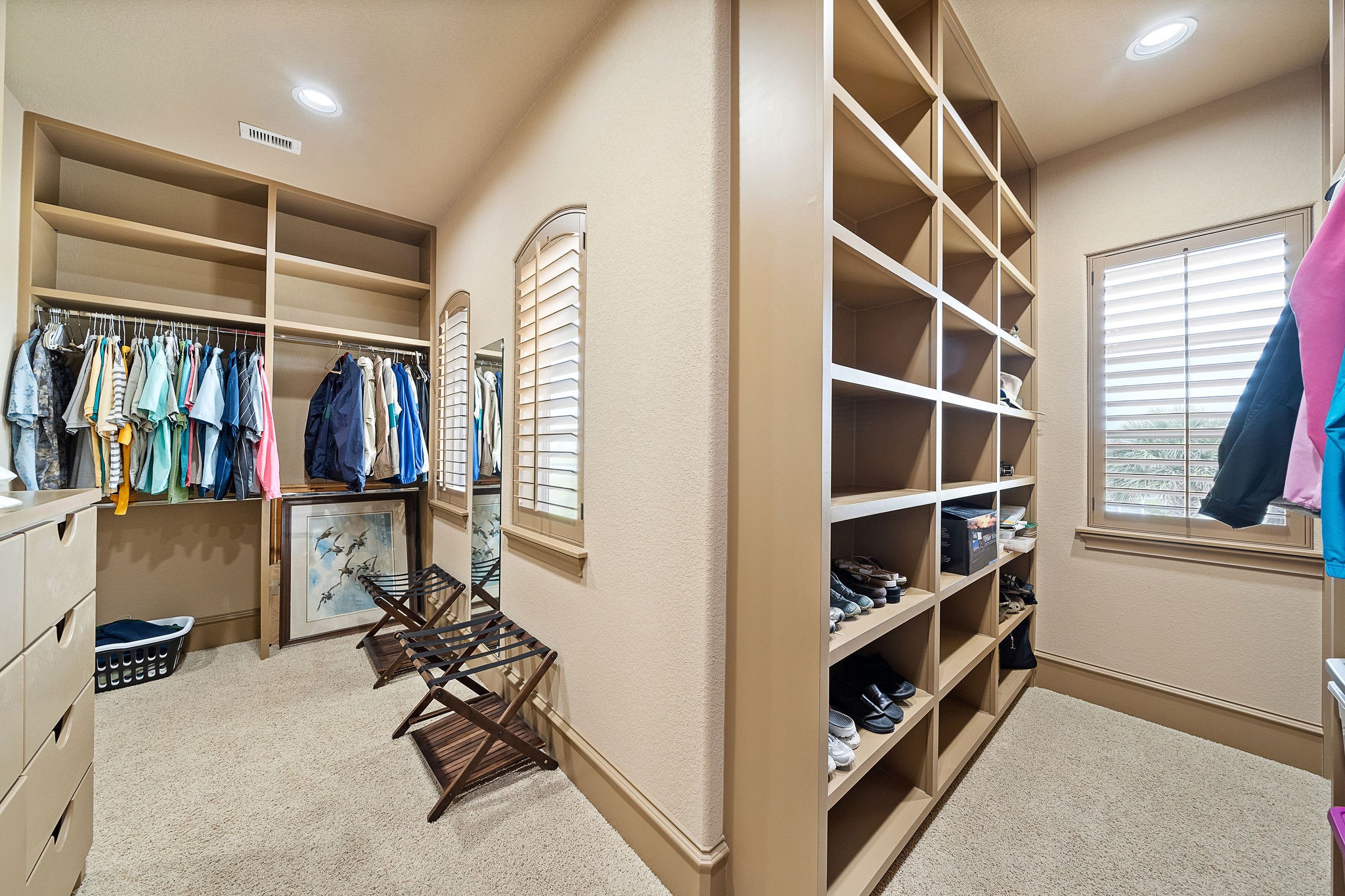 With custom built-in cabinetry, the primary bedroom closet is a perfect blend of luxury and practicality, offering abundant storage and a sleek, tailored look