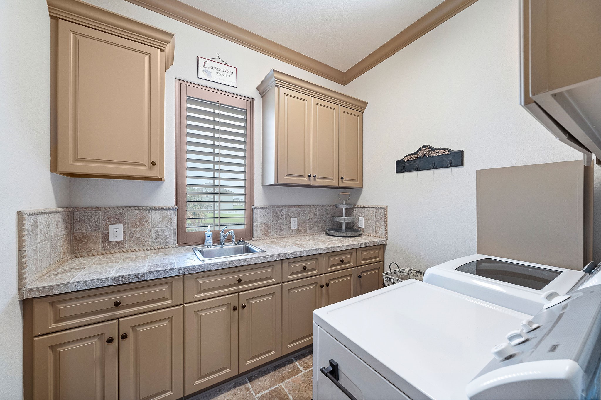 The spacious utility room is designed for both functionality and ease, with ample storage and beautifully tiled counter space...and a waterfront view