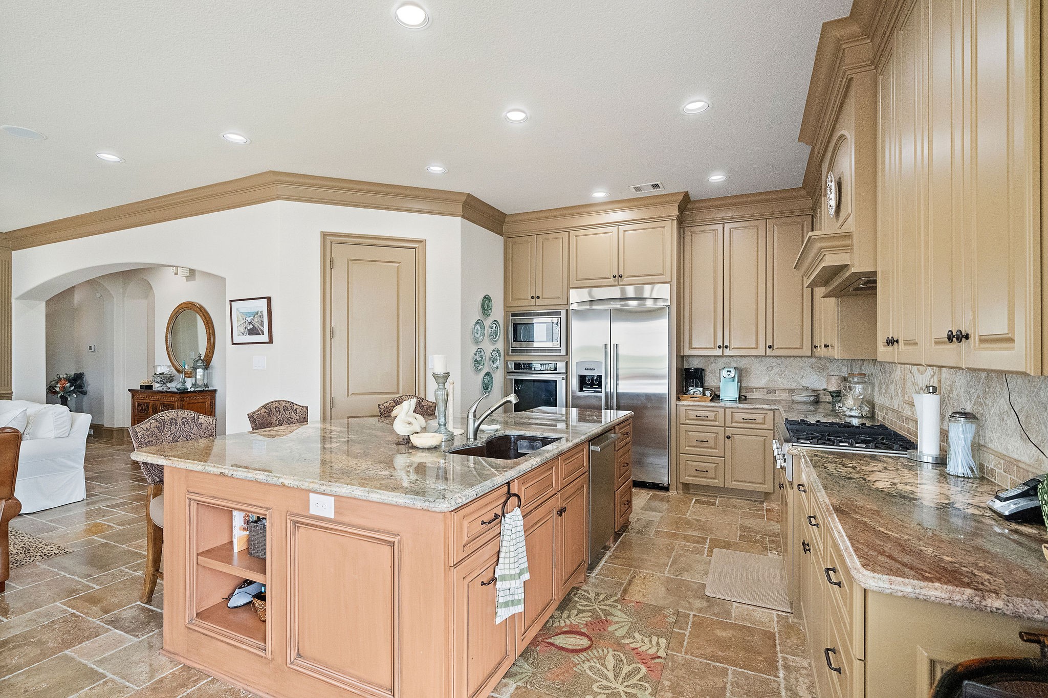 The island kitchen impresses with granite countertops, custom cabinets with plenty of storage and breakfast bar