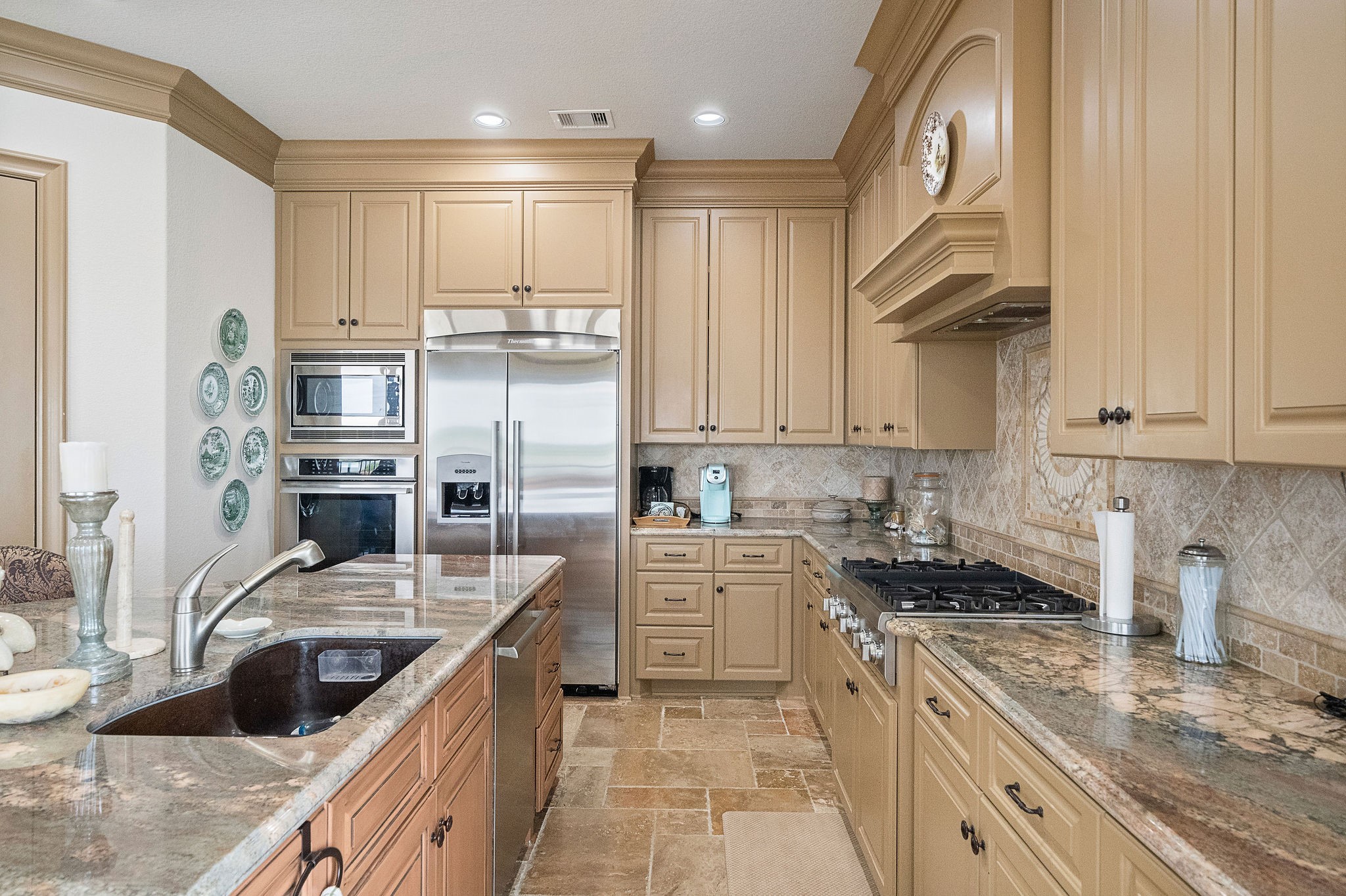 Designed for both beauty and function, this dream kitchen includes full-height cabinetry, stainless steel appliances, plentiful storage, and a walk-in pantry