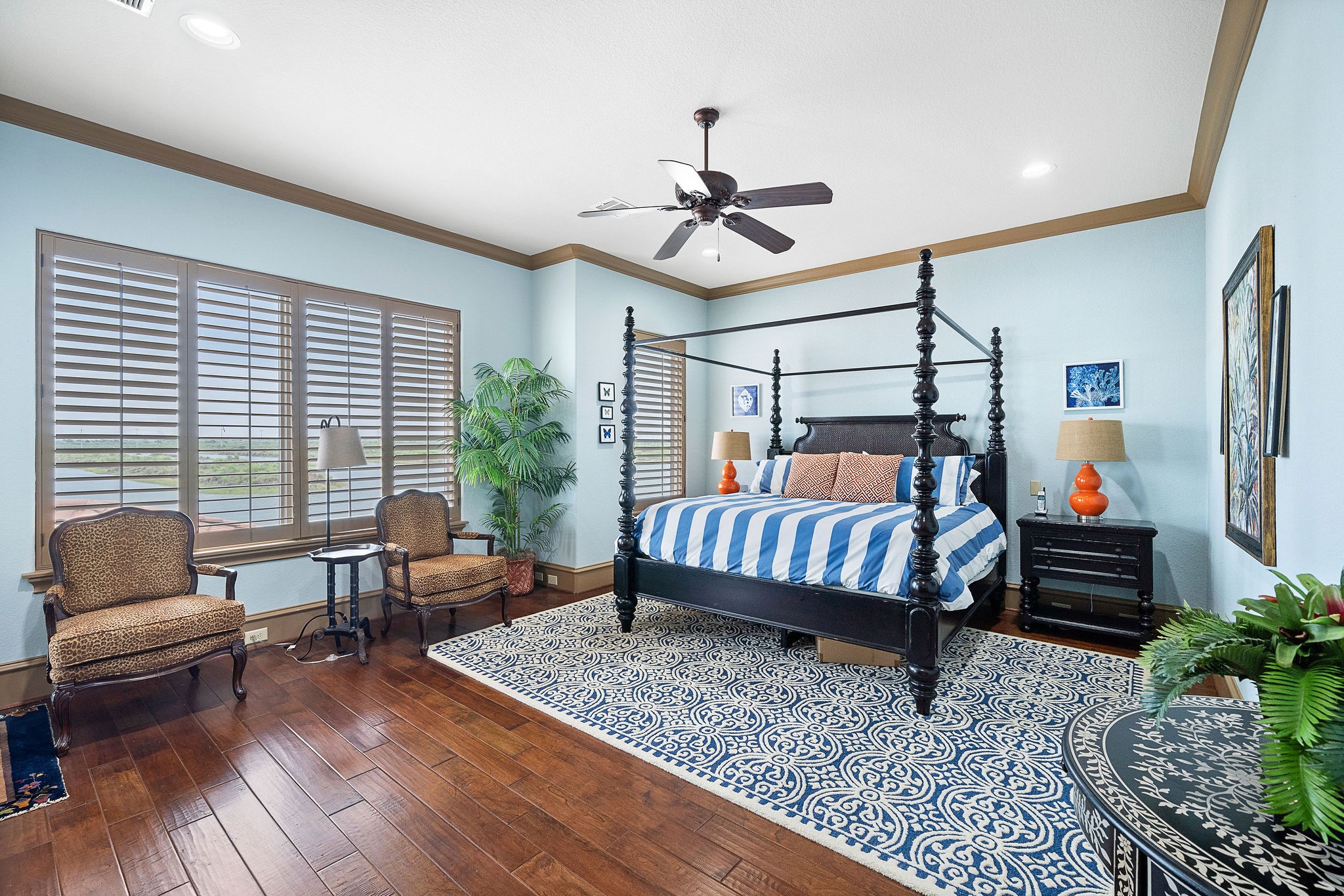 The large primary suite offers beautiful hardwood flooring and captivating waterfront views