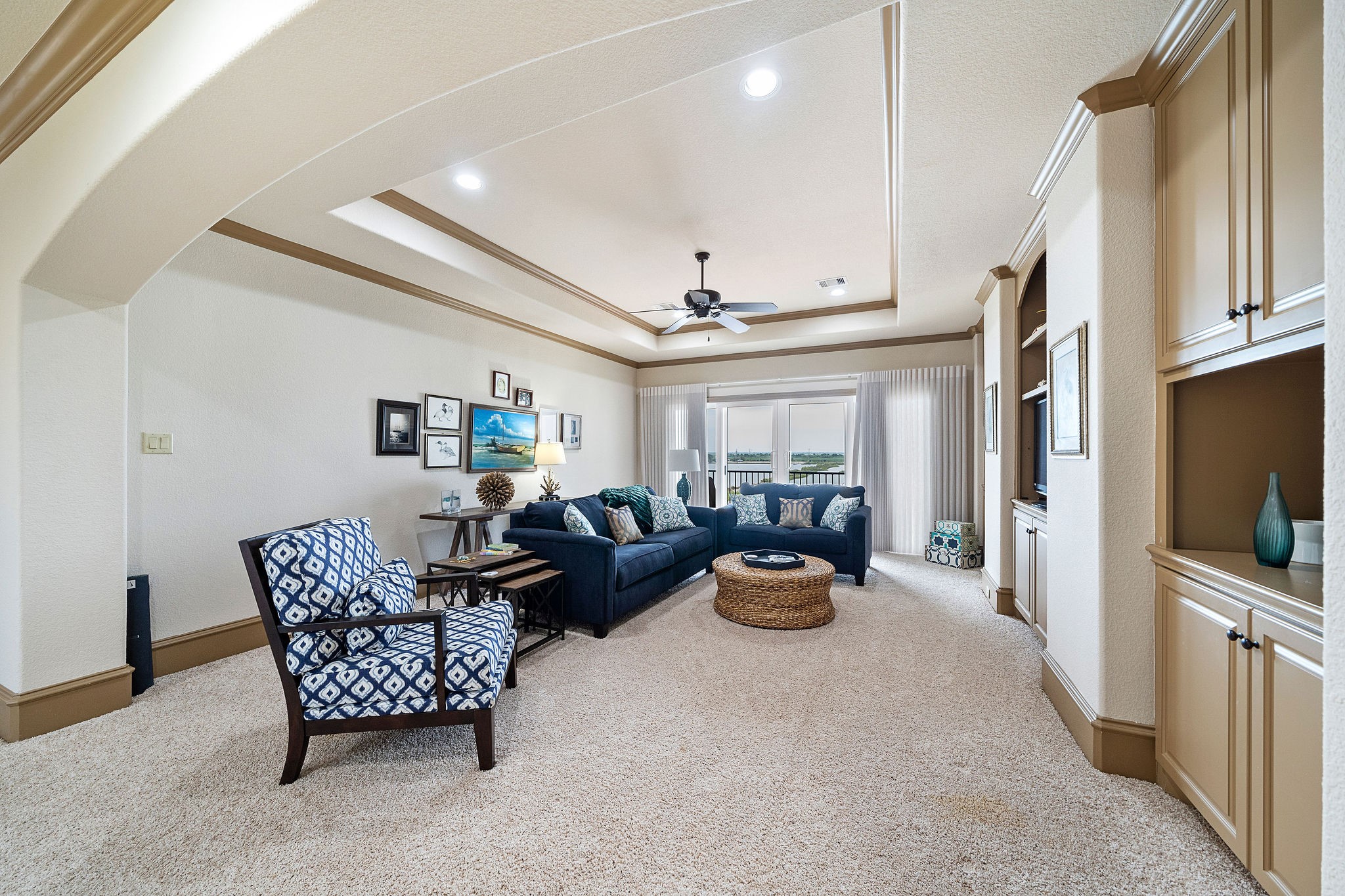 This expansive game/media room on the upper level provides convenient access to the third-floor terrace, creating an ideal space for both indoor and outdoor enjoyment