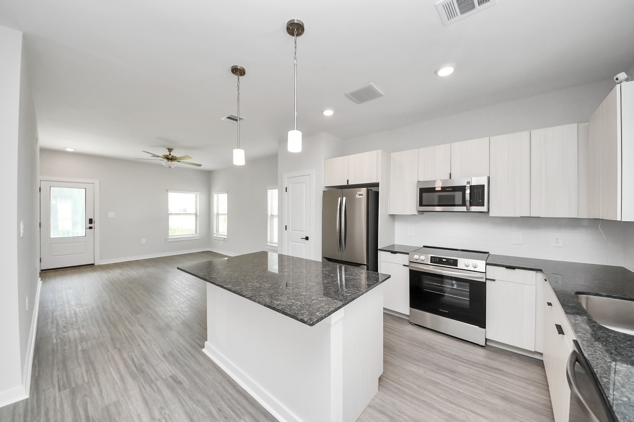 Boasting luxury finishes-stylish Island kitchen,granite counters,subway tile backsplash,ample custom cabinet space,stainless appliances,refrigerator,full size washer&dryer included,wood-like flooring throughout,open concept floor plan.