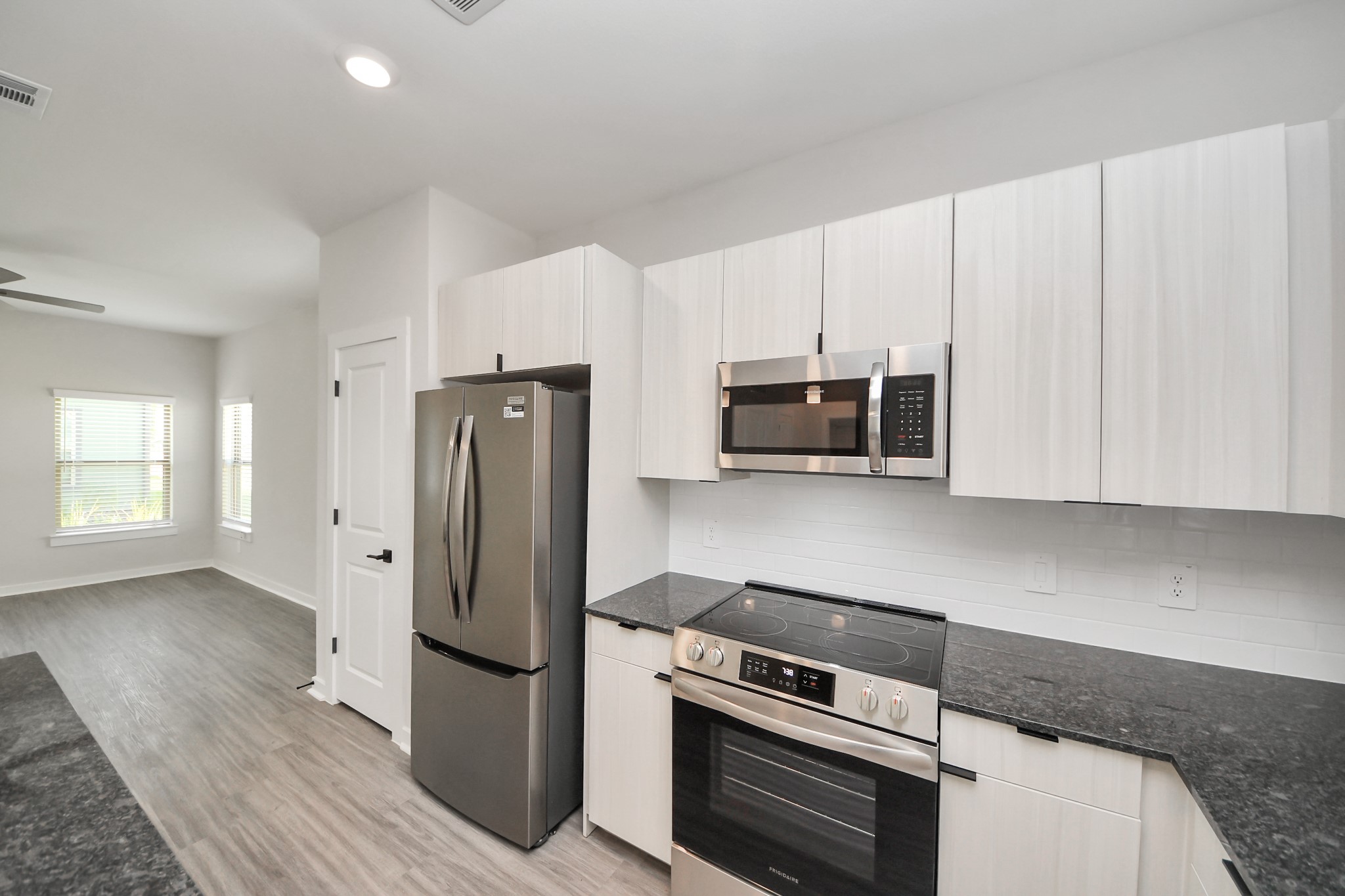 Boasting luxury finishes-stylish Island kitchen,granite counters,subway tile backsplash,ample custom cabinet space,stainless appliances,refrigerator,full size washer&dryer included,wood-like flooring throughout,open concept floor plan.