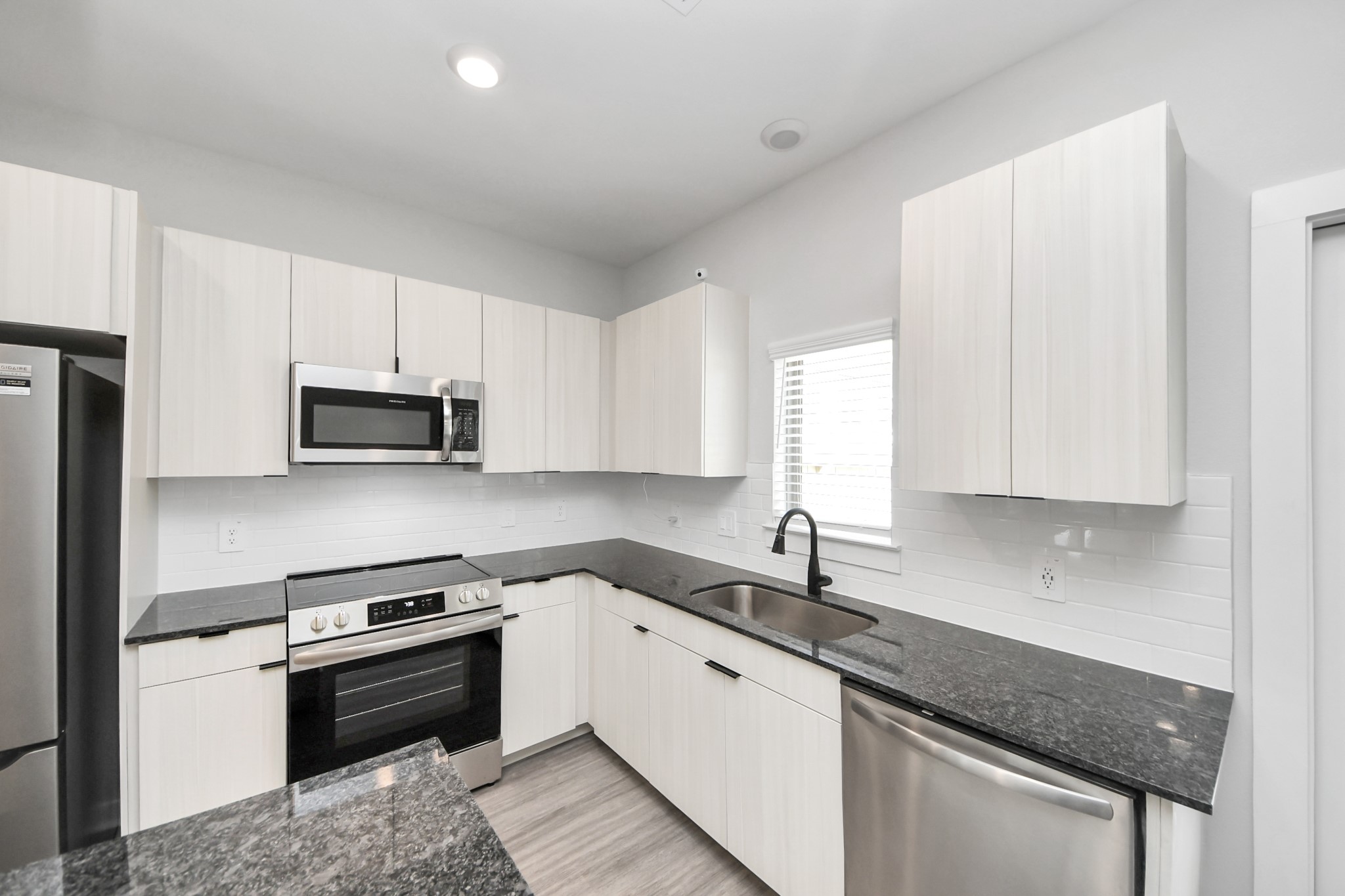 Boasting luxury finishes-stylish Island kitchen,granite counters,subway tile backsplash,ample custom cabinet space,stainless appliances,refrigerator,full size washer&dryer included,wood-like flooring throughout,open concept floor plan.