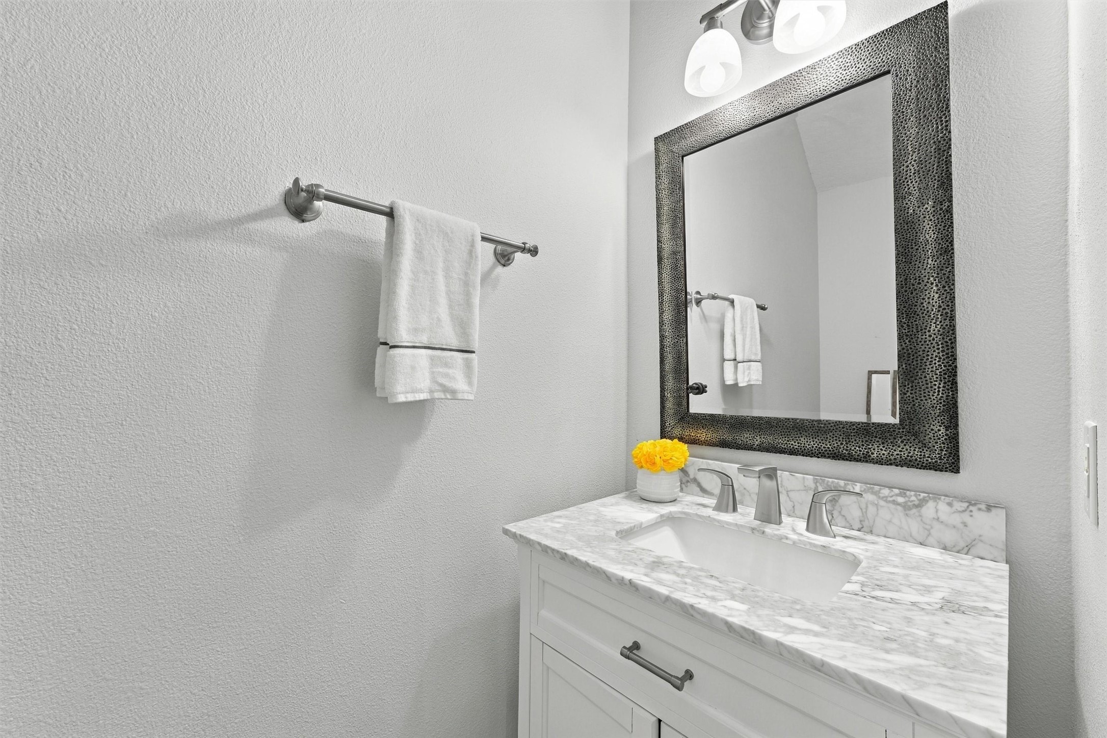 Convenient half bathroom featuring a pedestal sink and decorative mirror.