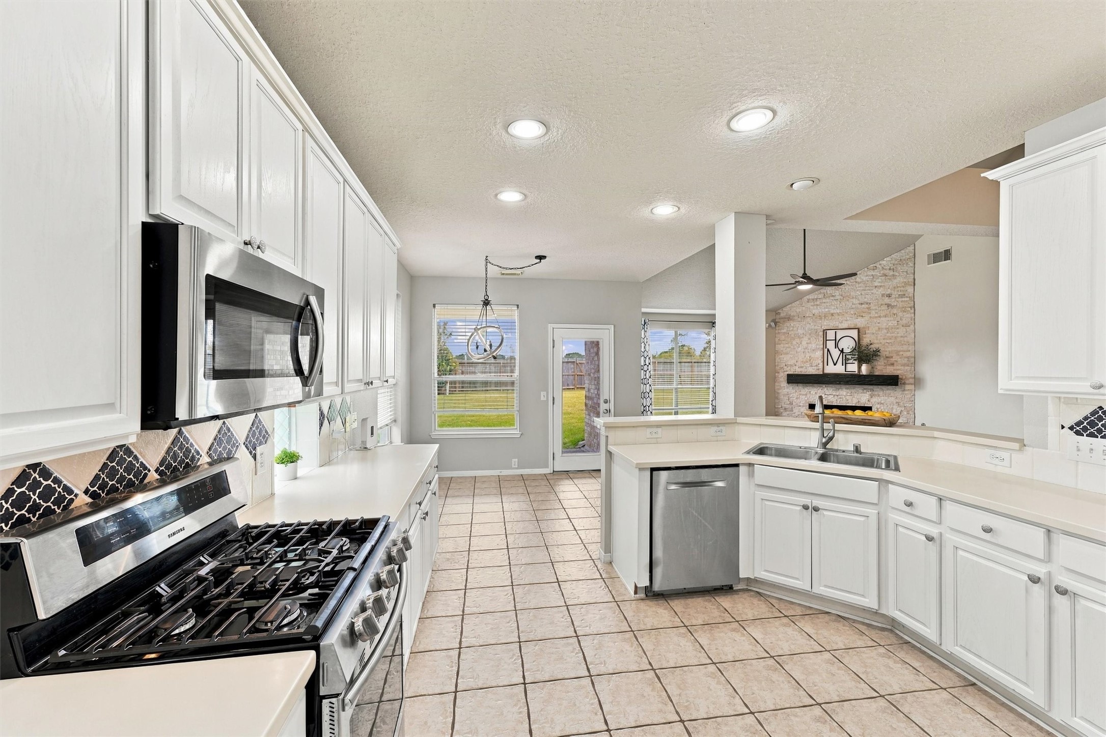 Another view of the kitchen showcasing stainless steel appliances and an abundance of storage.