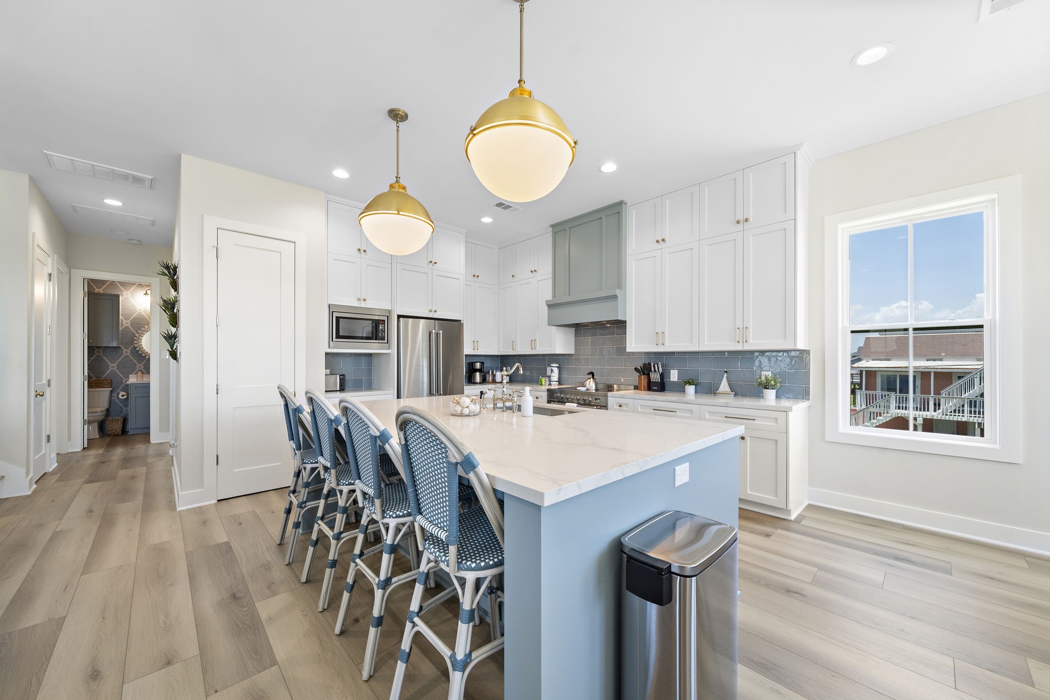 Bright and spacious kitchen featuring a large island with seating, elegant pendant lighting, and sleek stainless steel appliances, all complemented by a stylish backsplash and ample cabinetry. Bright and spacious kitchen featuring a large island with seating, elegant pendant lighting, and sleek stainless steel appliances, all complemented by a stylish backsplash and ample cabinetry.