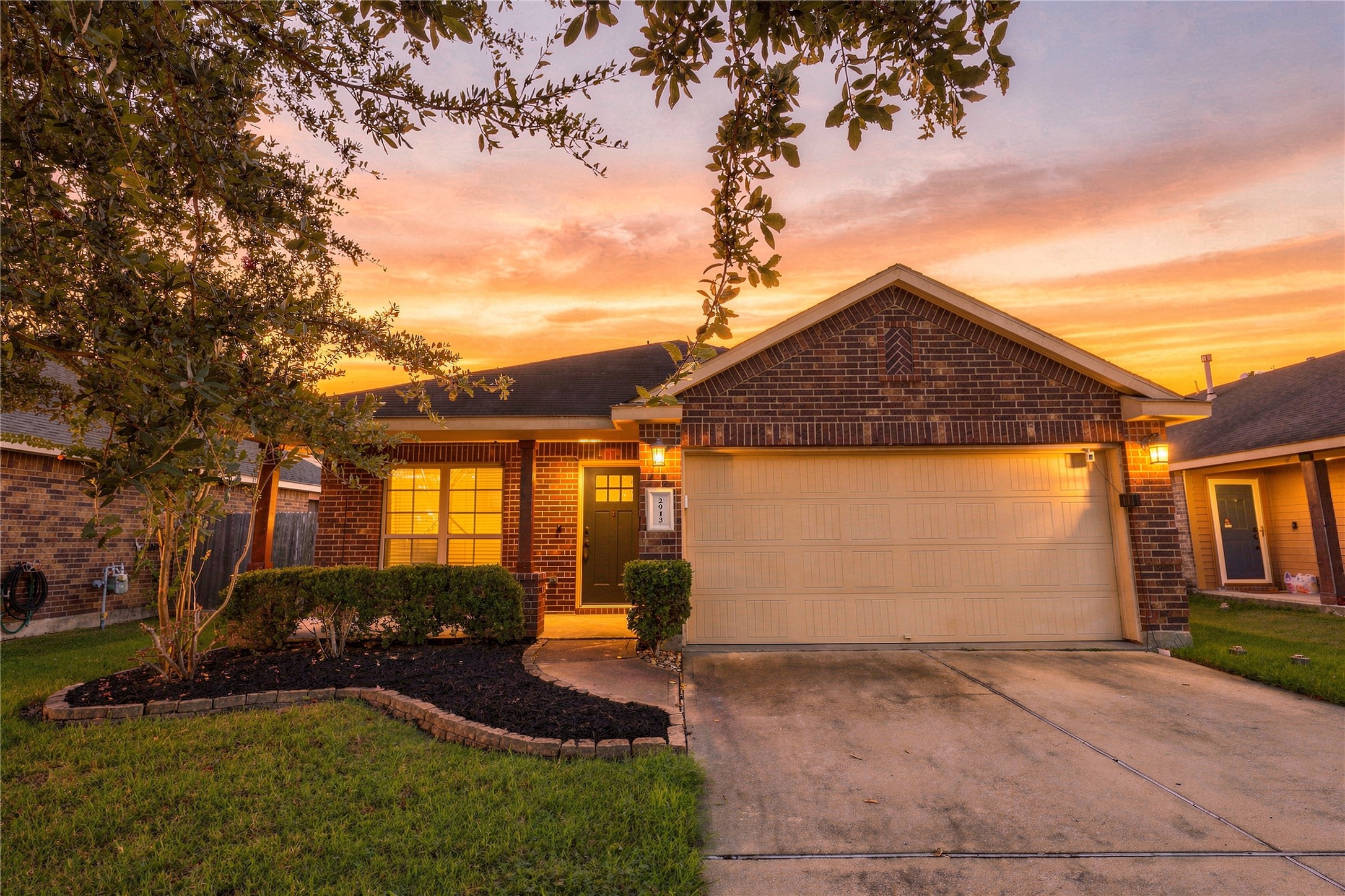 Twilight exterior showcasing the homes brick elevation, mature landscaping, and 2-car garage. Twilight exterior showcasing the homes brick elevation, mature landscaping, and 2-car garage.