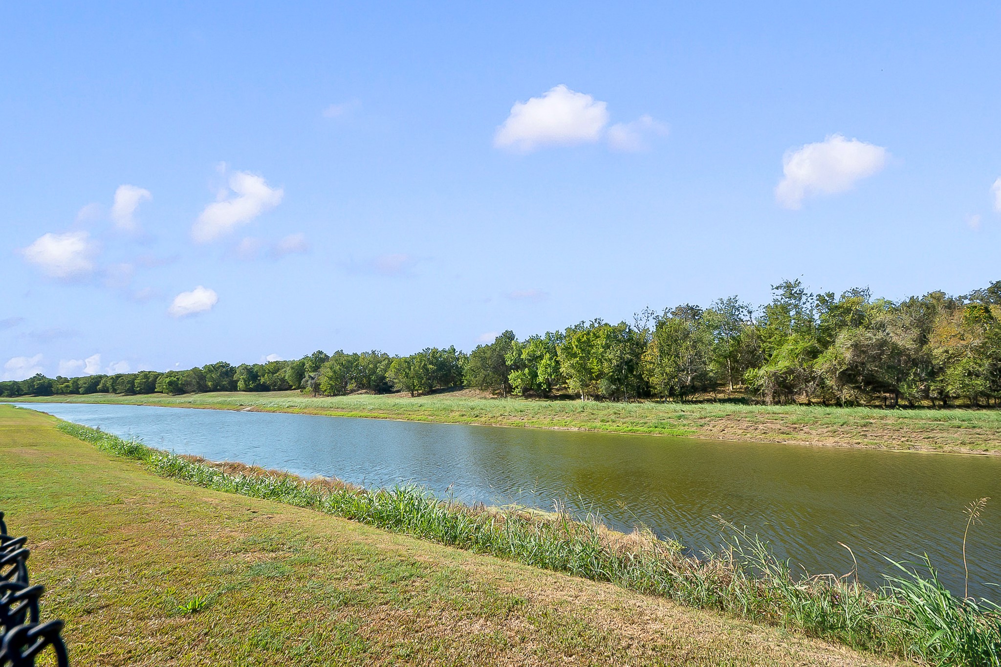 Tranquil waterfront views with lush greenery and a serene, expansive sky create a perfect backdrop for relaxation and outdoor enjoyment.