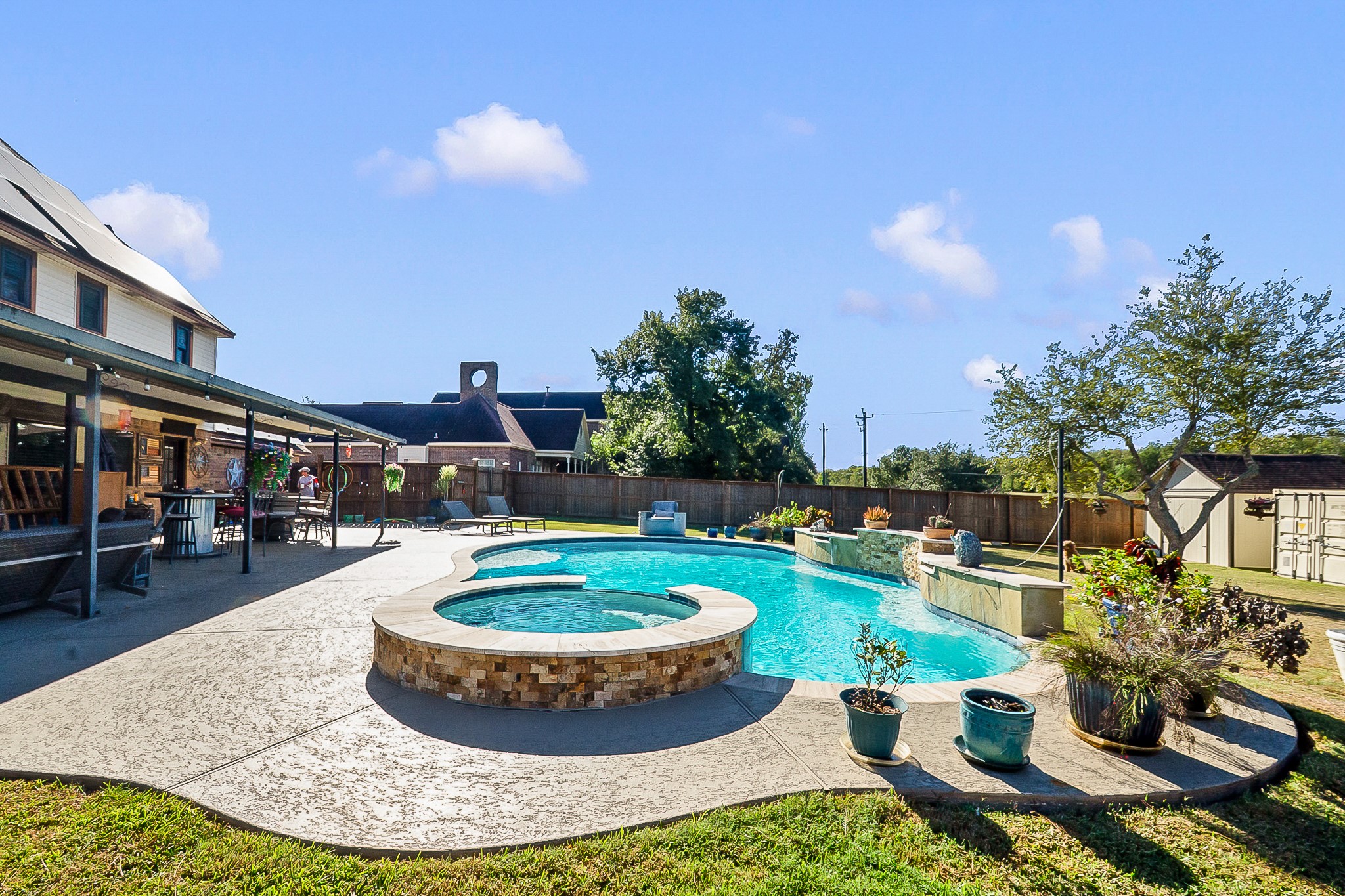 Spacious backyard oasis featuring a luxurious 450 sq. ft. heated pool with a spa, ample patio space for entertaining, and lush landscaping for privacy and relaxation.