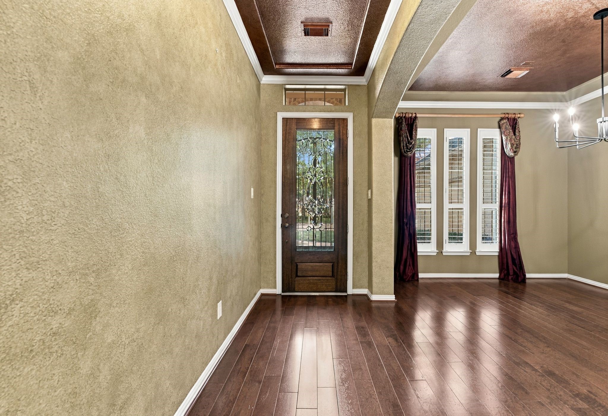 Elegant entryway with rich wood flooring, a decorative glass front door. Elegant entryway with rich wood flooring, a decorative glass front door.