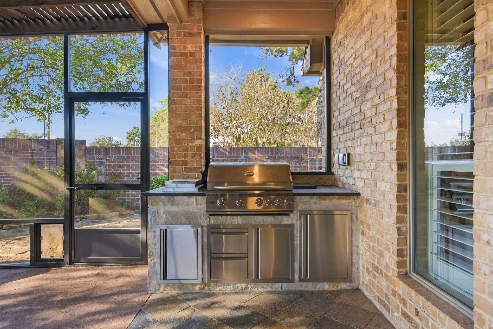 Charming outdoor kitchen featuring a stainless-steel grill.