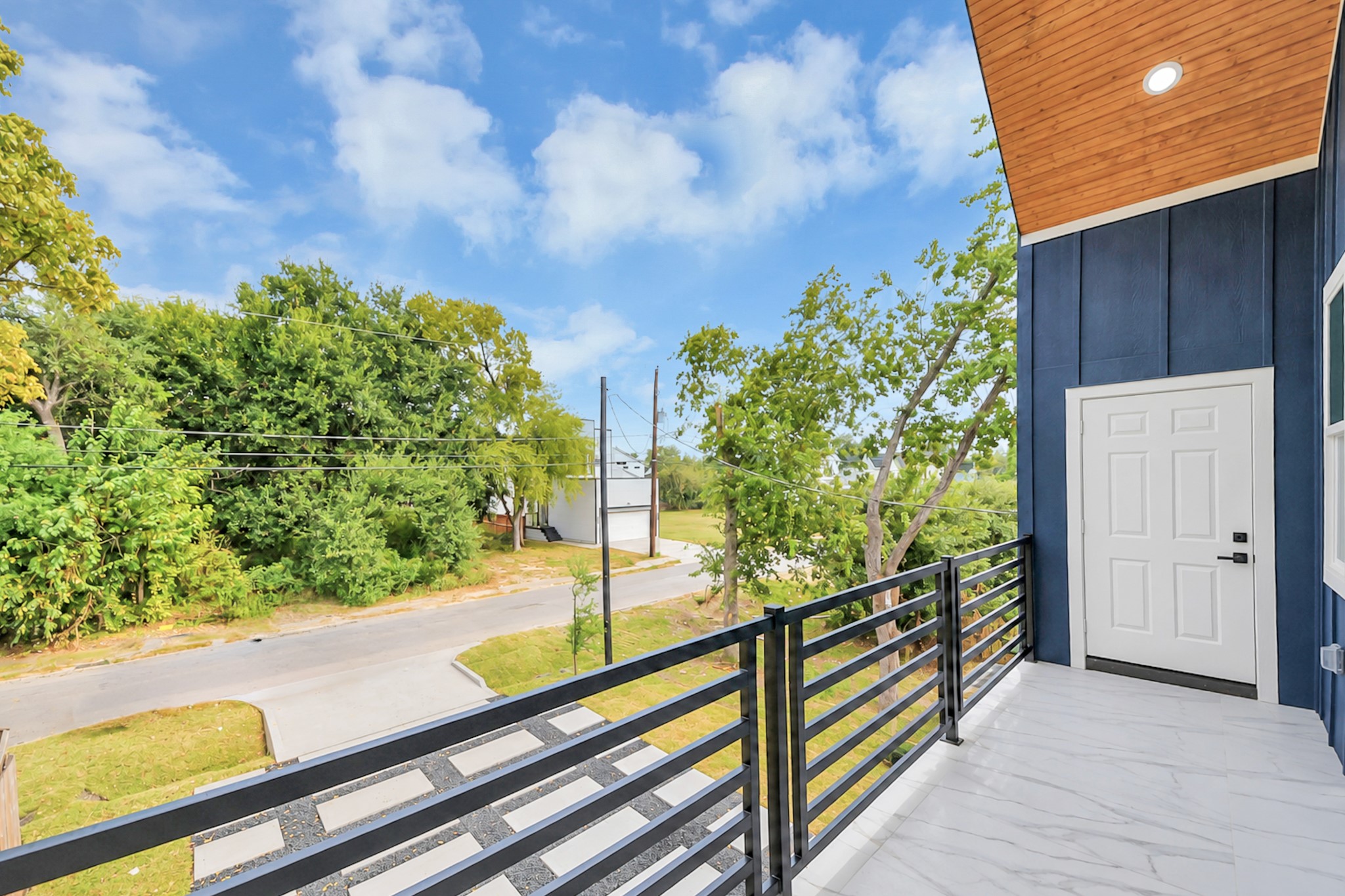 Charming balcony with sleek railing offers a serene view of lush greenery and a quiet street, perfect for relaxation. Charming balcony with sleek railing offers a serene view of lush greenery and a quiet street, perfect for relaxation.