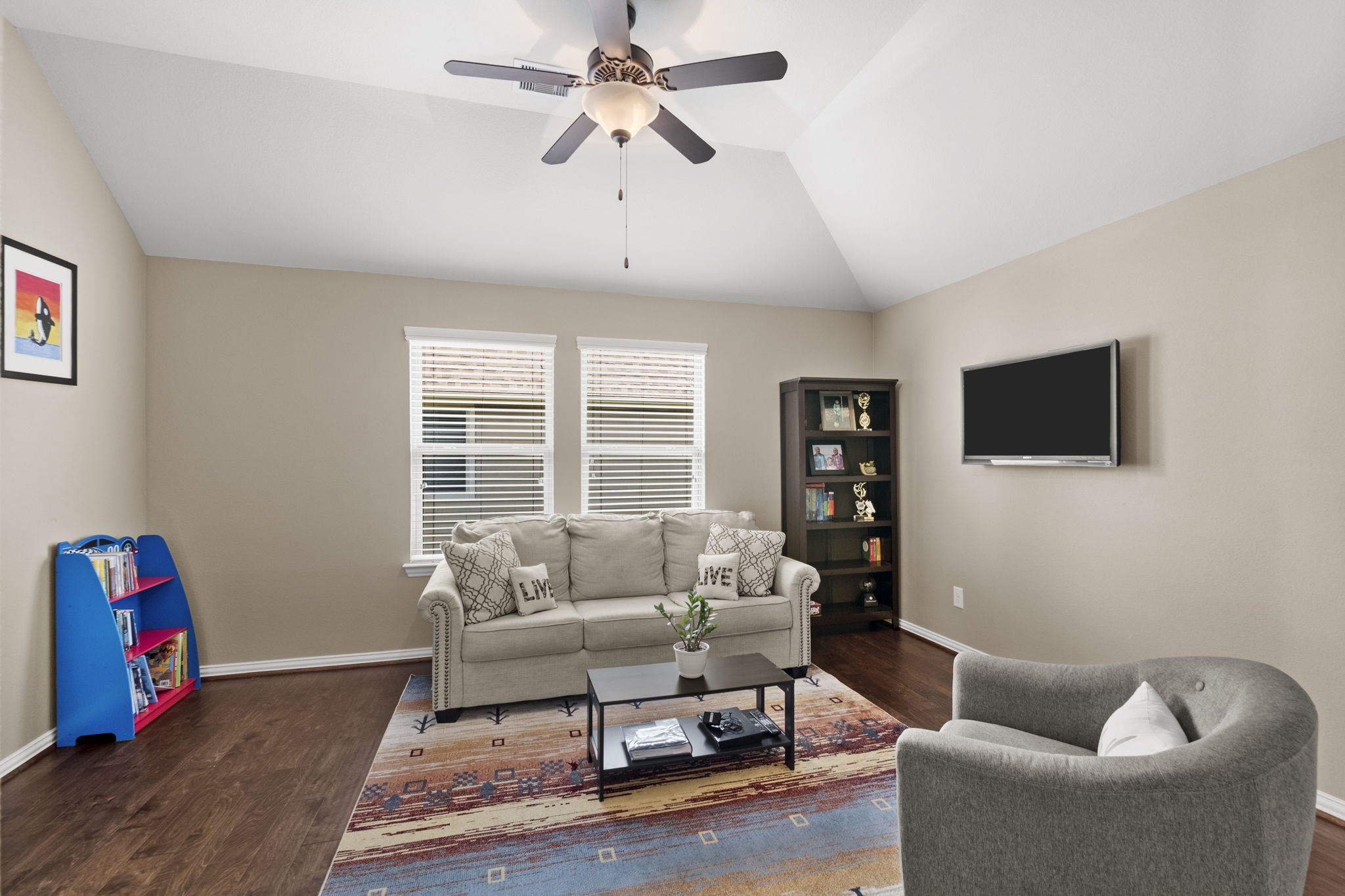 The upstairs game room with wood floors & vaulted ceilings provides a comfortable space for relaxation & entertainment.