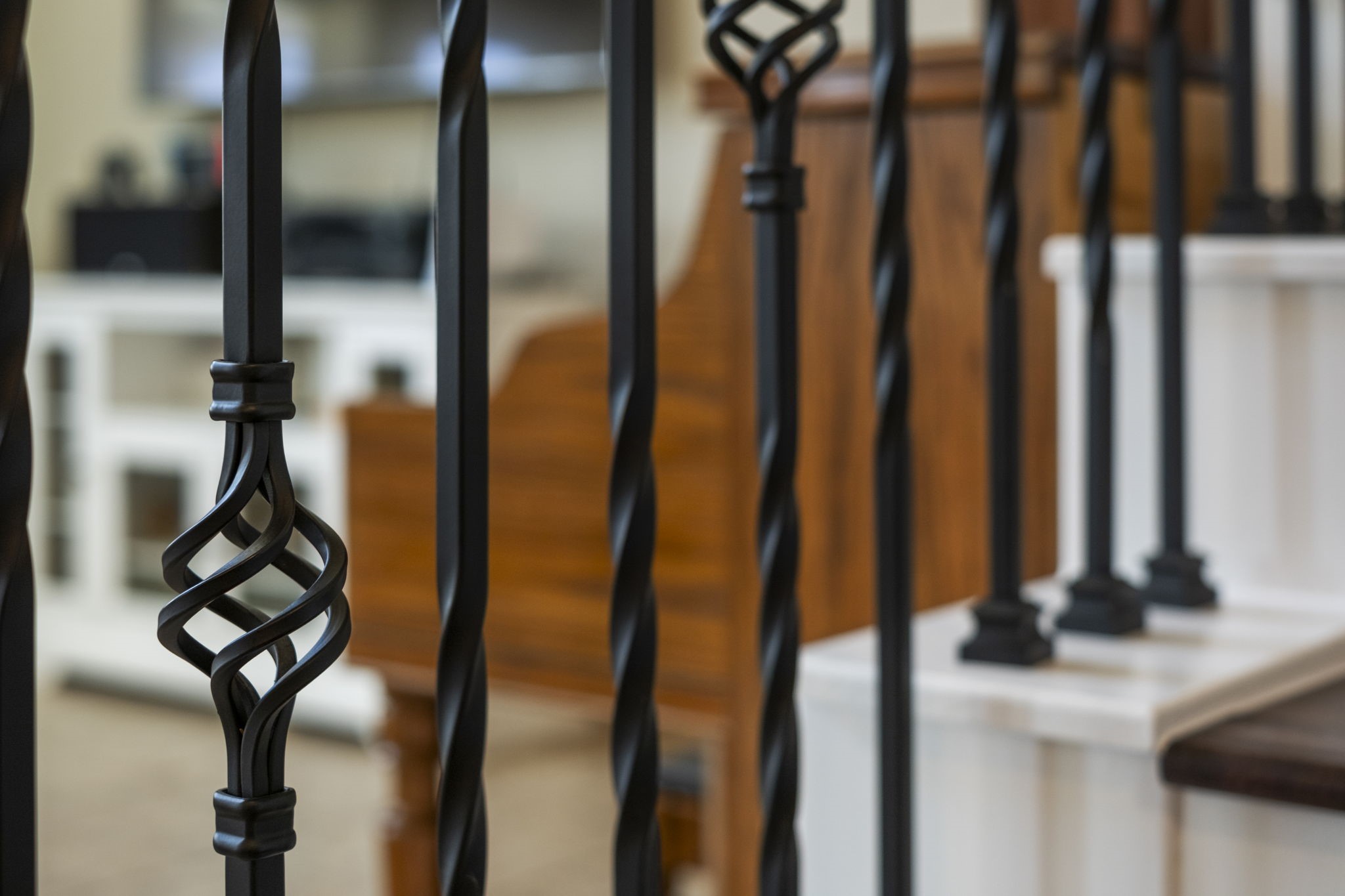 The staircase offers elegant black wrought iron balusters featuring intricate designs, complemented by wooden steps.