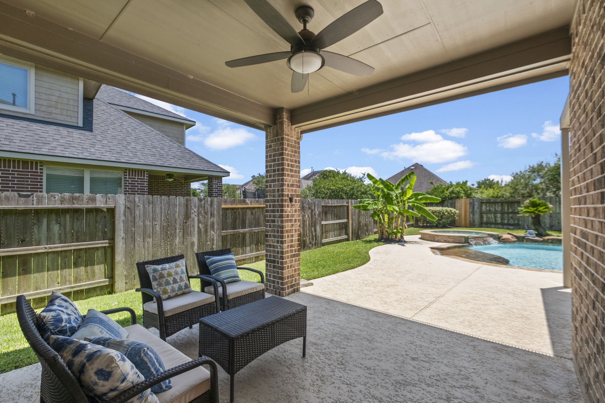 A covered patio provides a comfortable seating area & overlooks a well-maintained backyard.