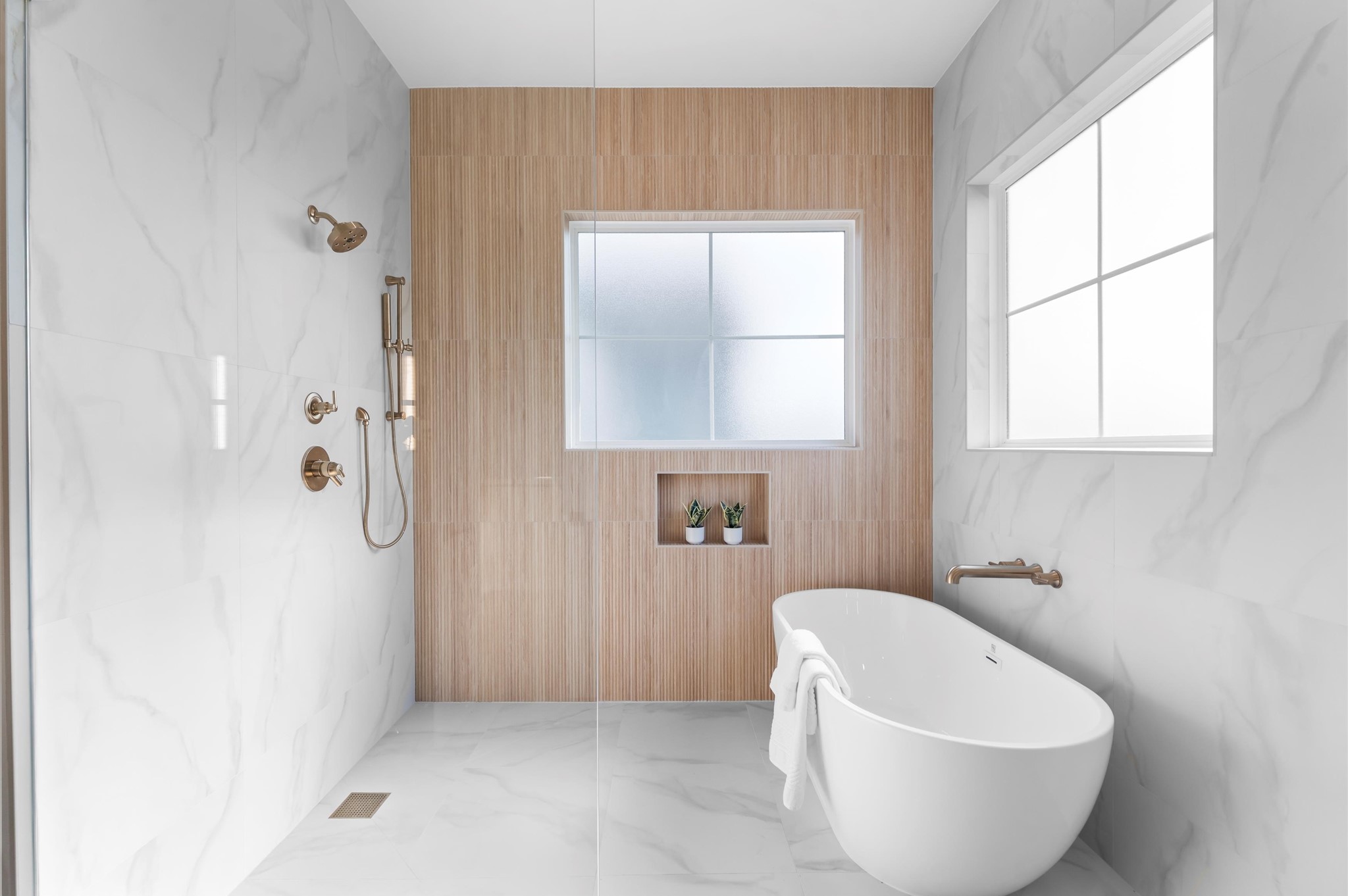 Primary bath features curbless shower and separate soaking tub.