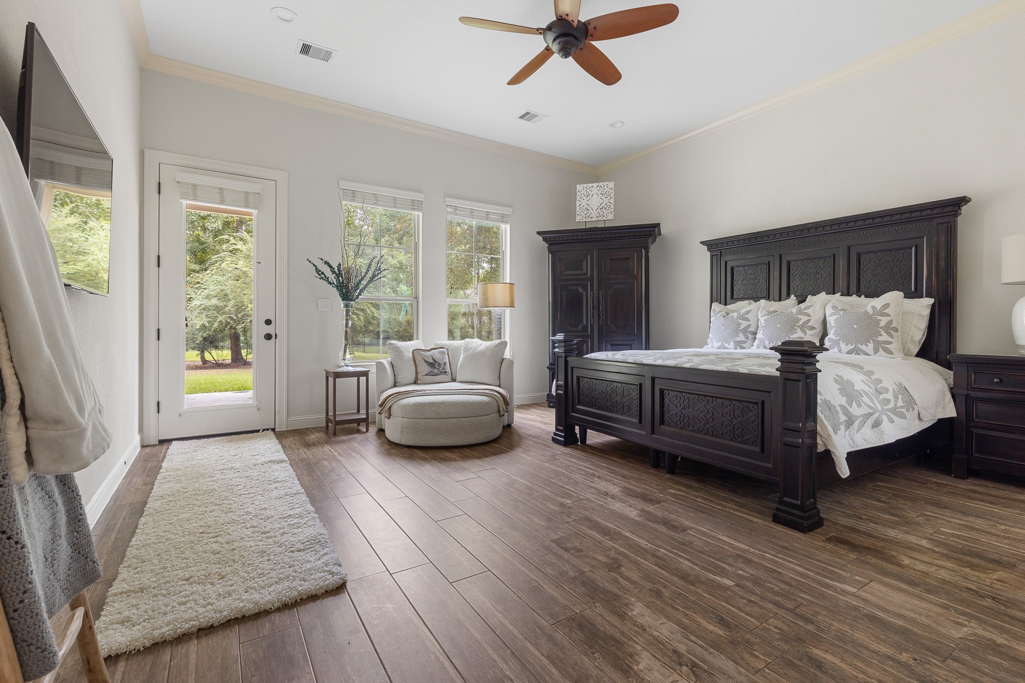 Primary bedroom with sitting area, access to backyard patio, ensuite bathroom and custom walk-in closet