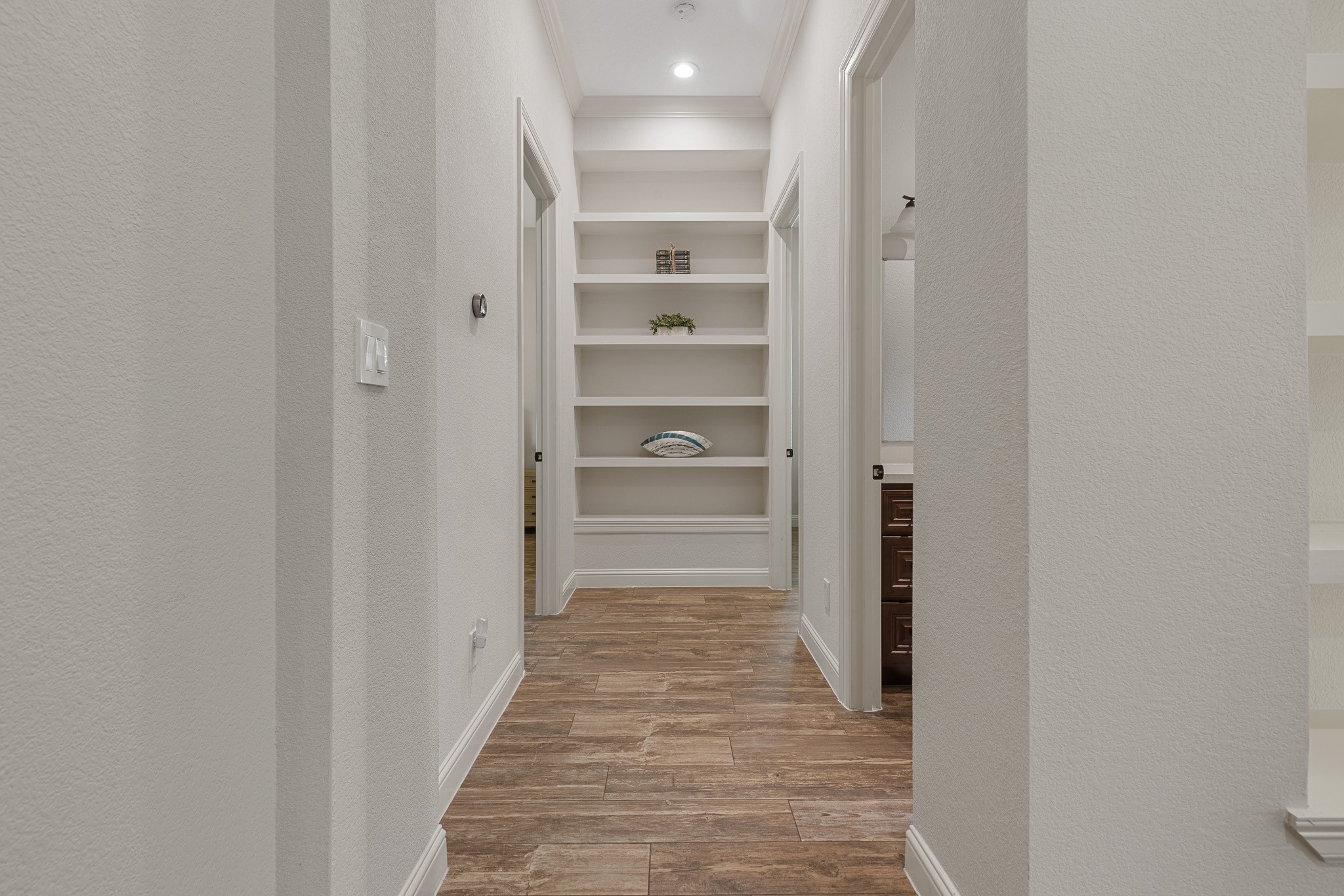 Hall with built-in shelving and recessed lighting.
