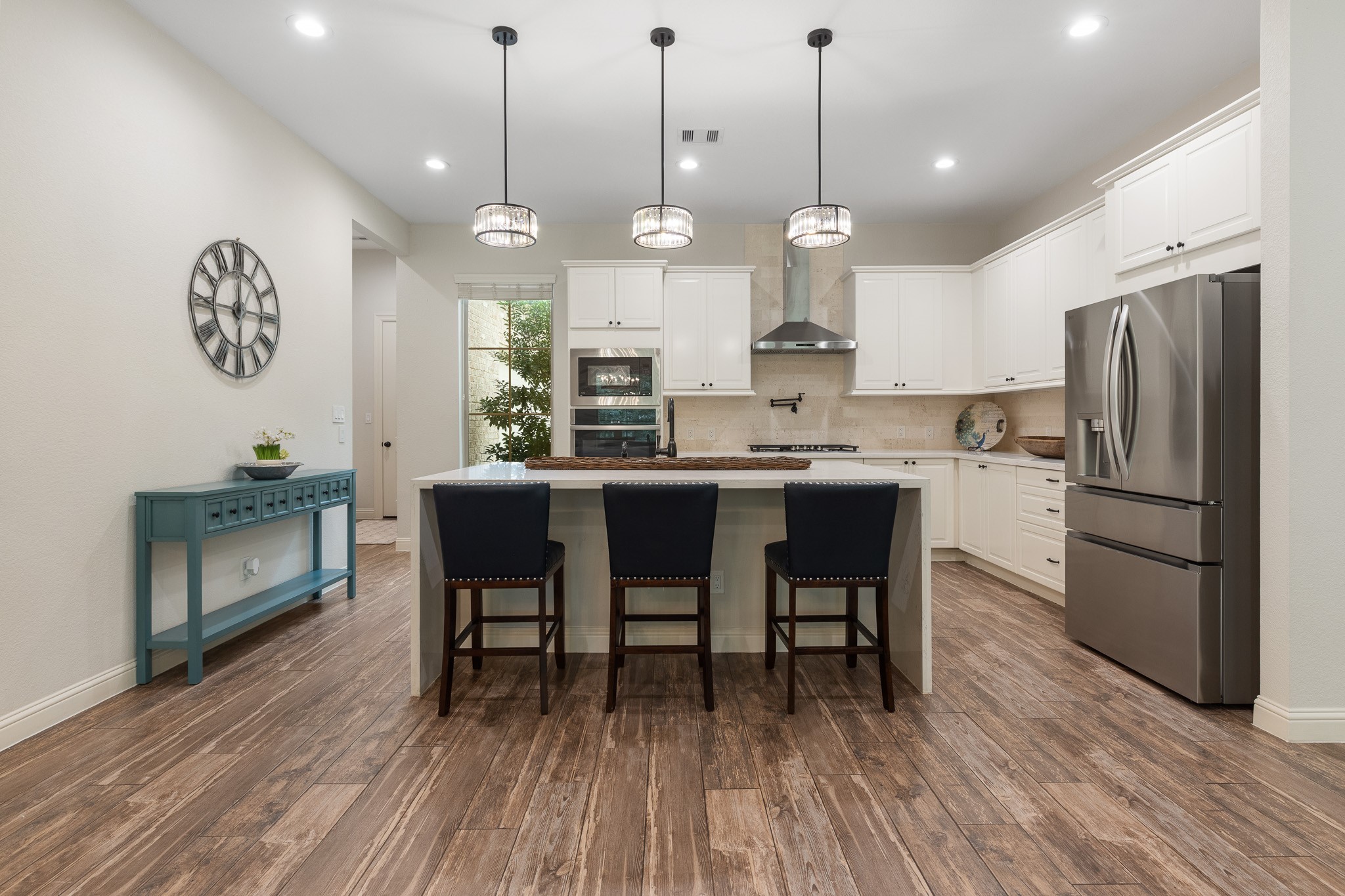 Kitchen with pendant lighting on a dimmer switch over waterfall island.