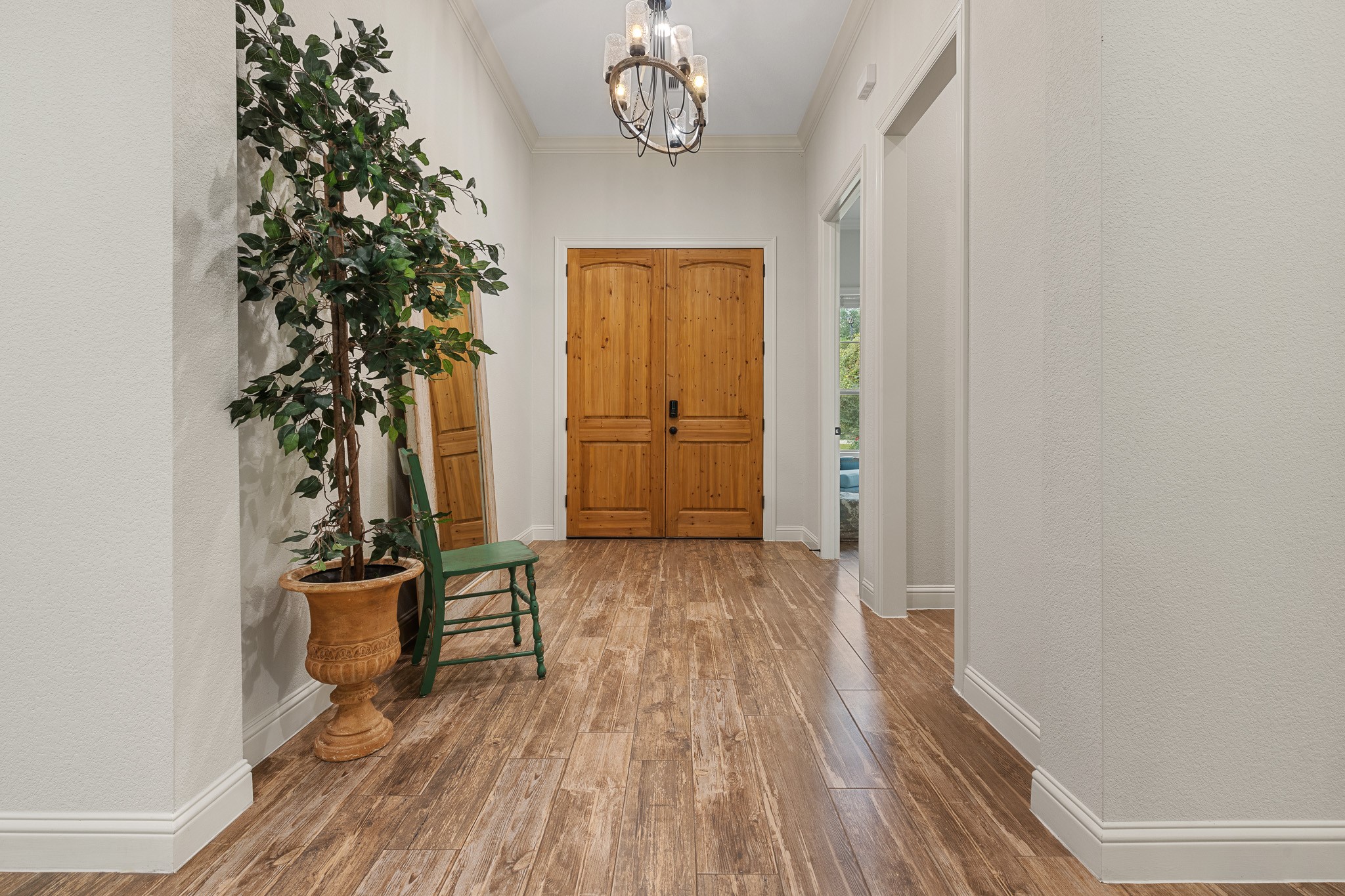 Wood doors at the front entry, wood look porcelain tile throughout.