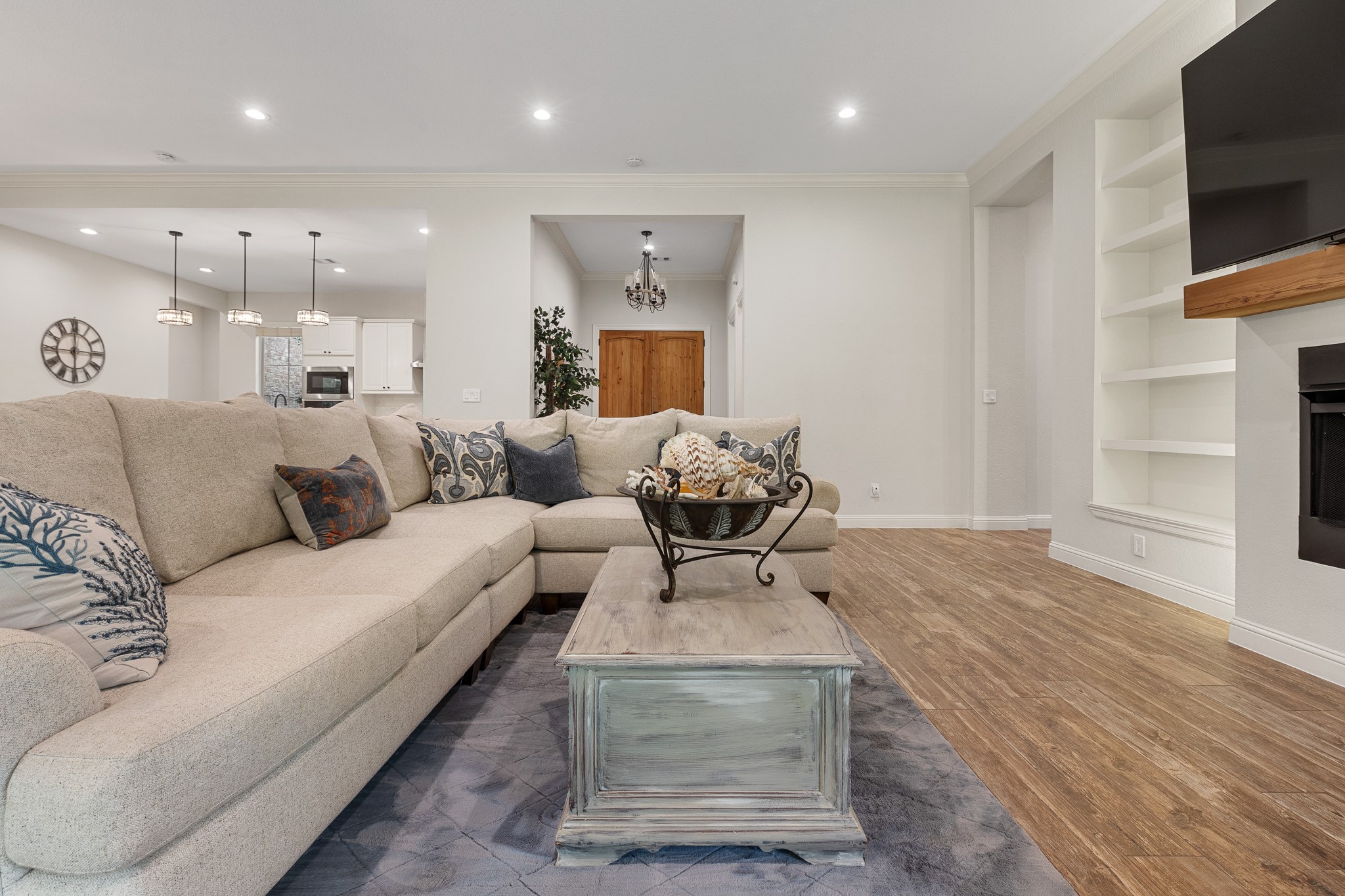 Living room with gas fireplace, recessed lighting, built-ins.