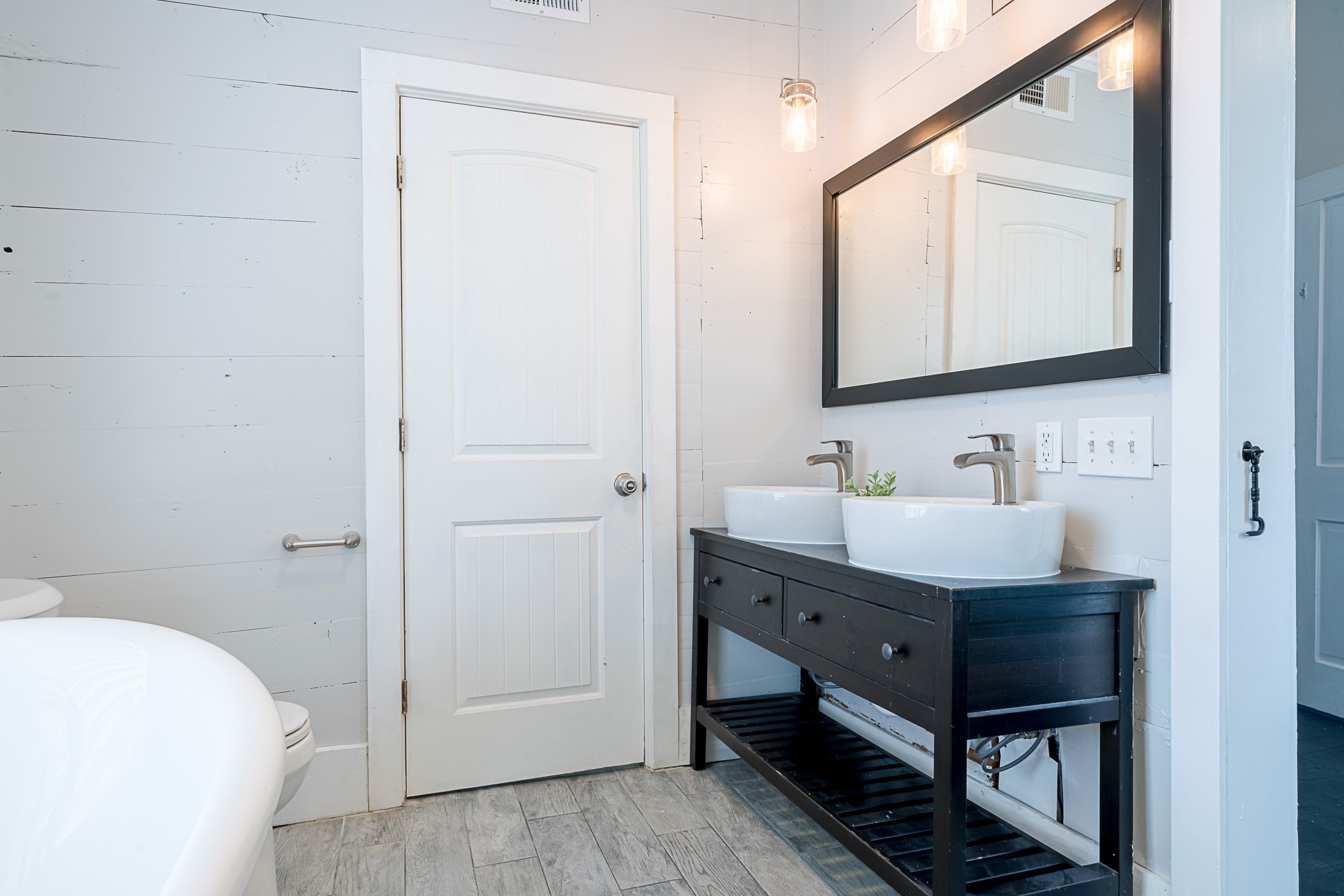 Beautifully upgraded primary bathroom with double sinks and framed mirror