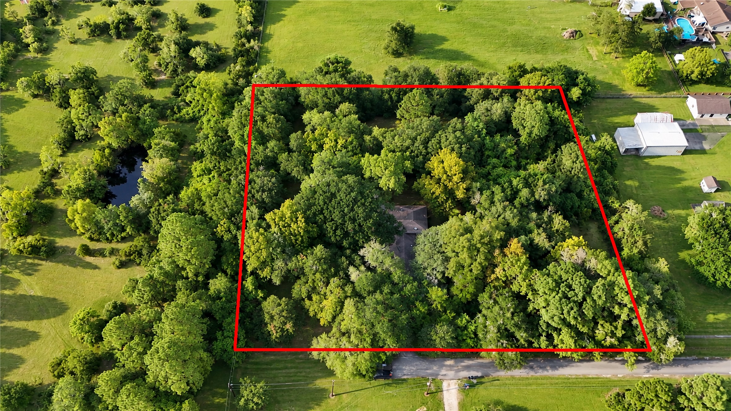 Little over 2 Acres with mature trees and a Pond to the right.
