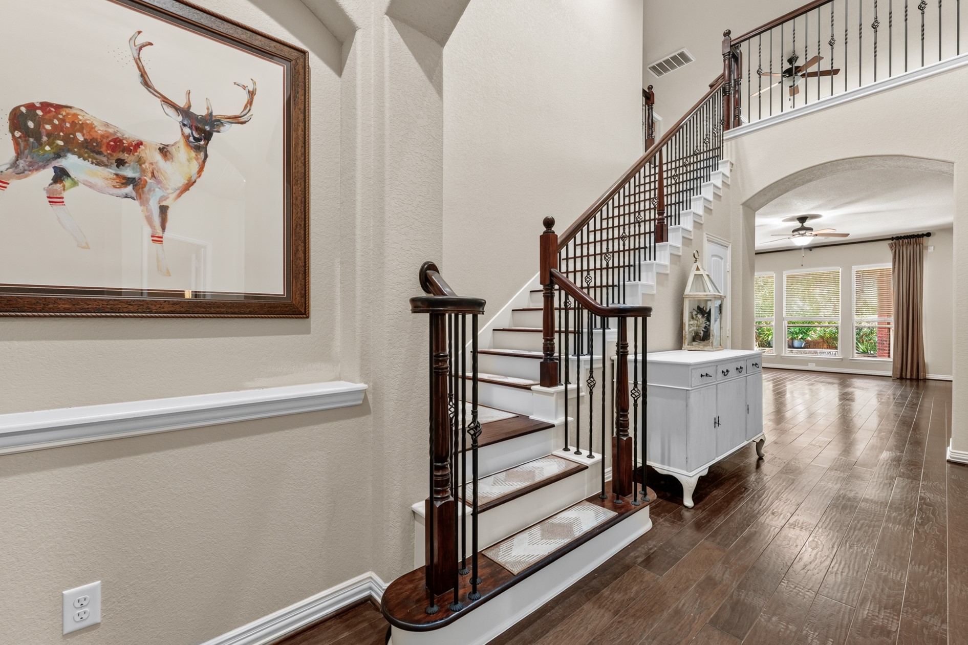 A gorgeous staircase with wood and iron balusters leads to the game room and media room.