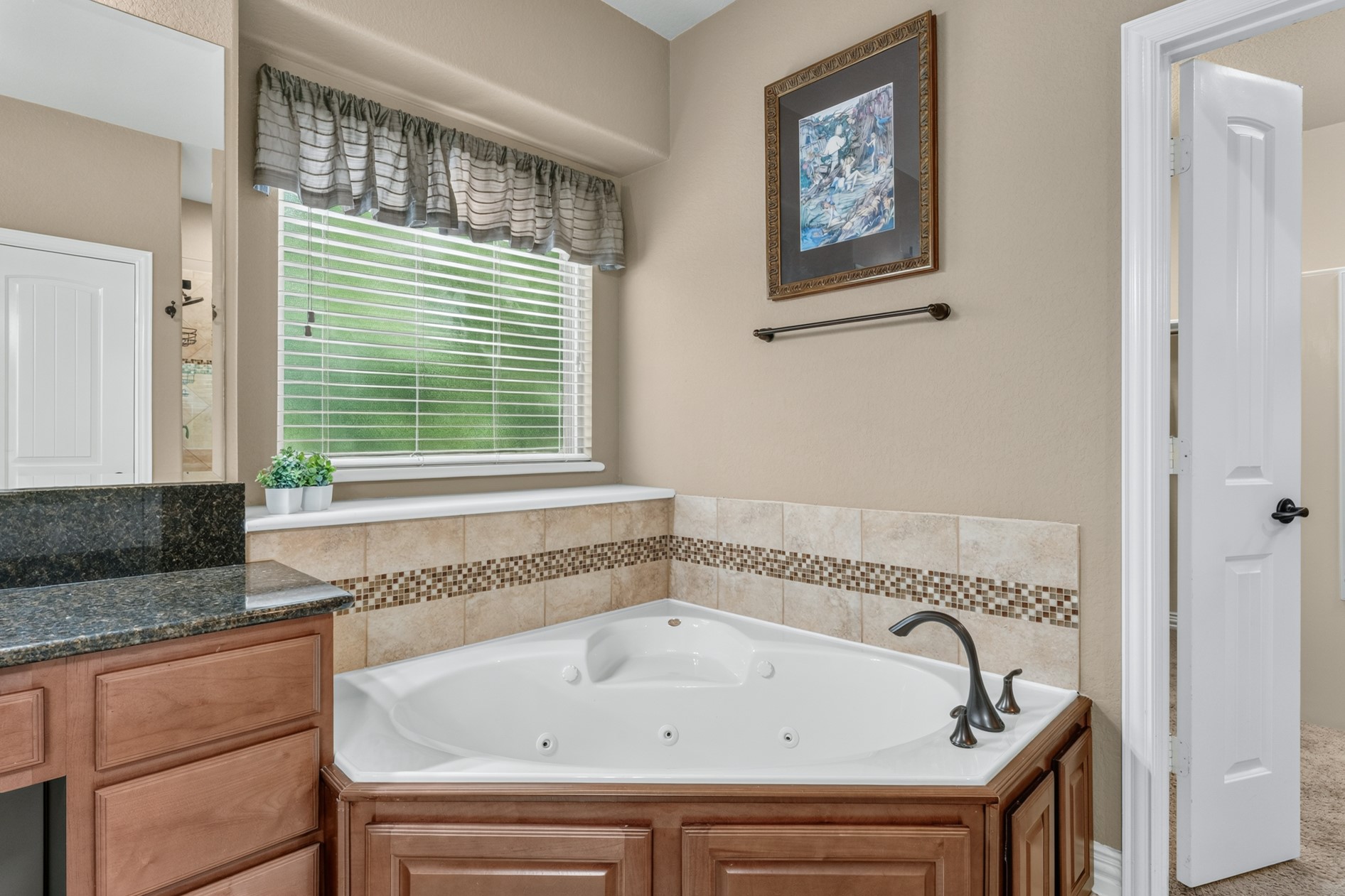 Take some time to relax in your large jetted tub.  A window with privacy glass lets in natural light.