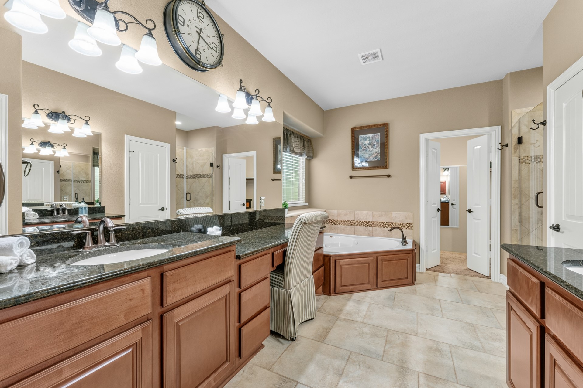Your spa-like ensuite features separate sinks and vanity areas, a jetted tub, separate walk-in shower, and linen closet for extra storage.