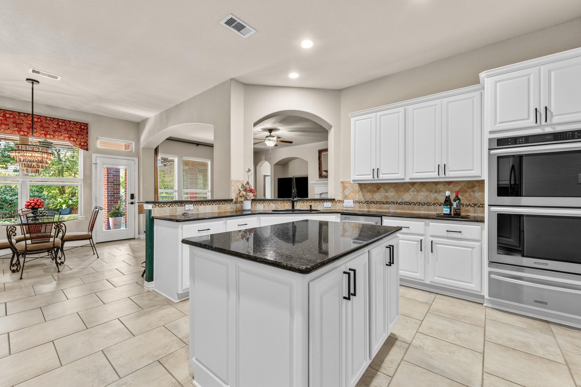 This spacious well-appointed kitchen will be enjoyed by all.  Lots of storage, tiled backsplash, timeless white cabinetry, and stainless steel appliances provide beauty and practicality for everyday living. Double-ovens and a warming drawer make cooking for large gatherings easy!
