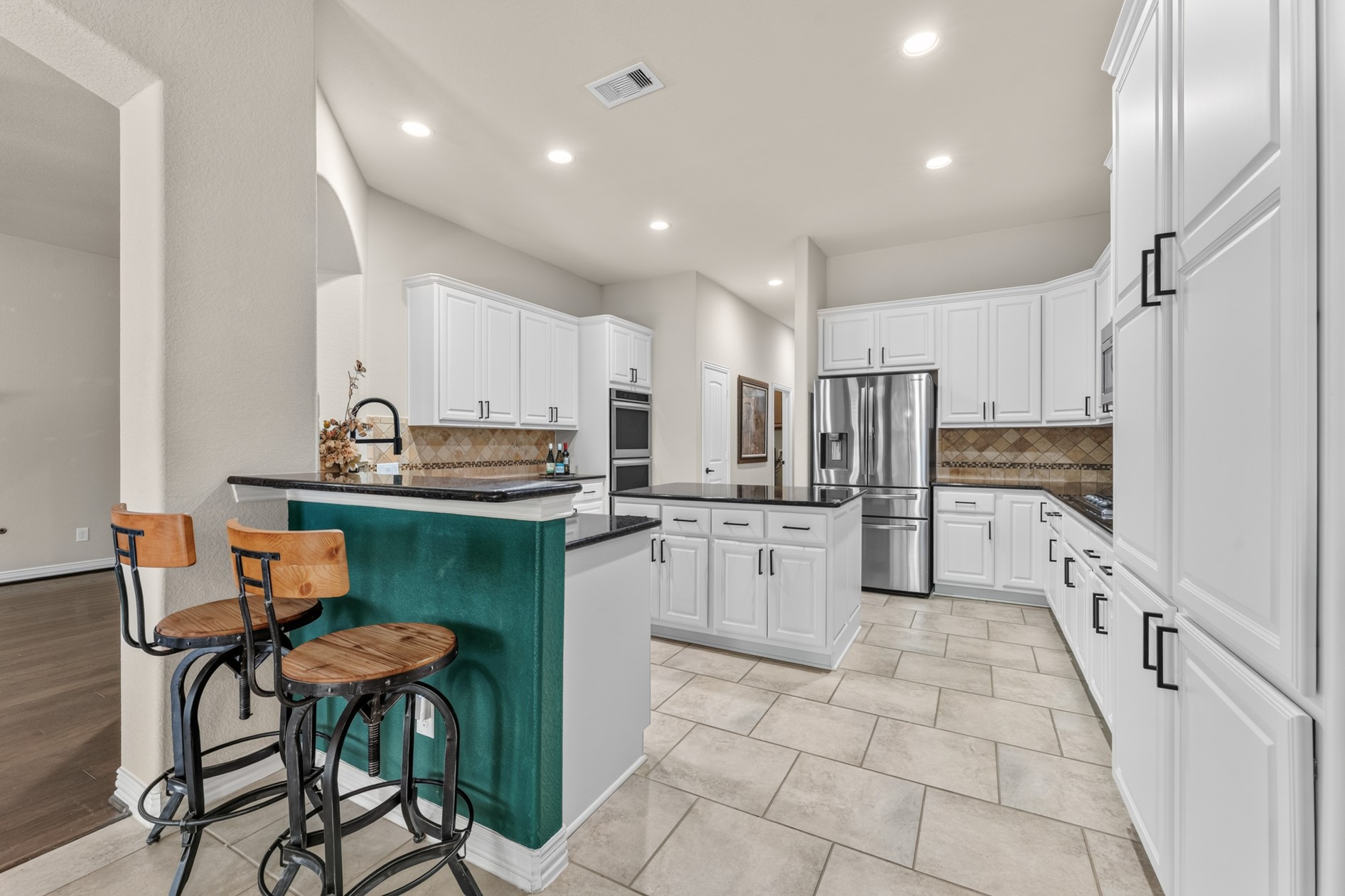 This roomy kitchen offers an abundance of storage with wrap around cabinets on three sides, cabinets in the island, a wall pantry, AND a walk-in pantry.