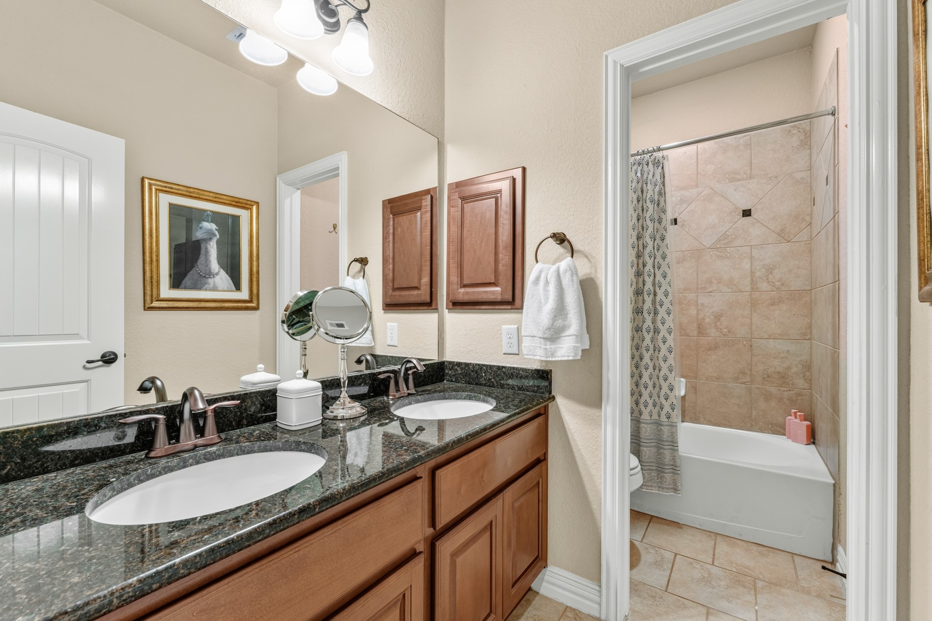 Morning prep is easy for everyone in this full bathroom featuring double sinks and a separated tub/shower area! It is across the hall from two of the guest bedrooms.