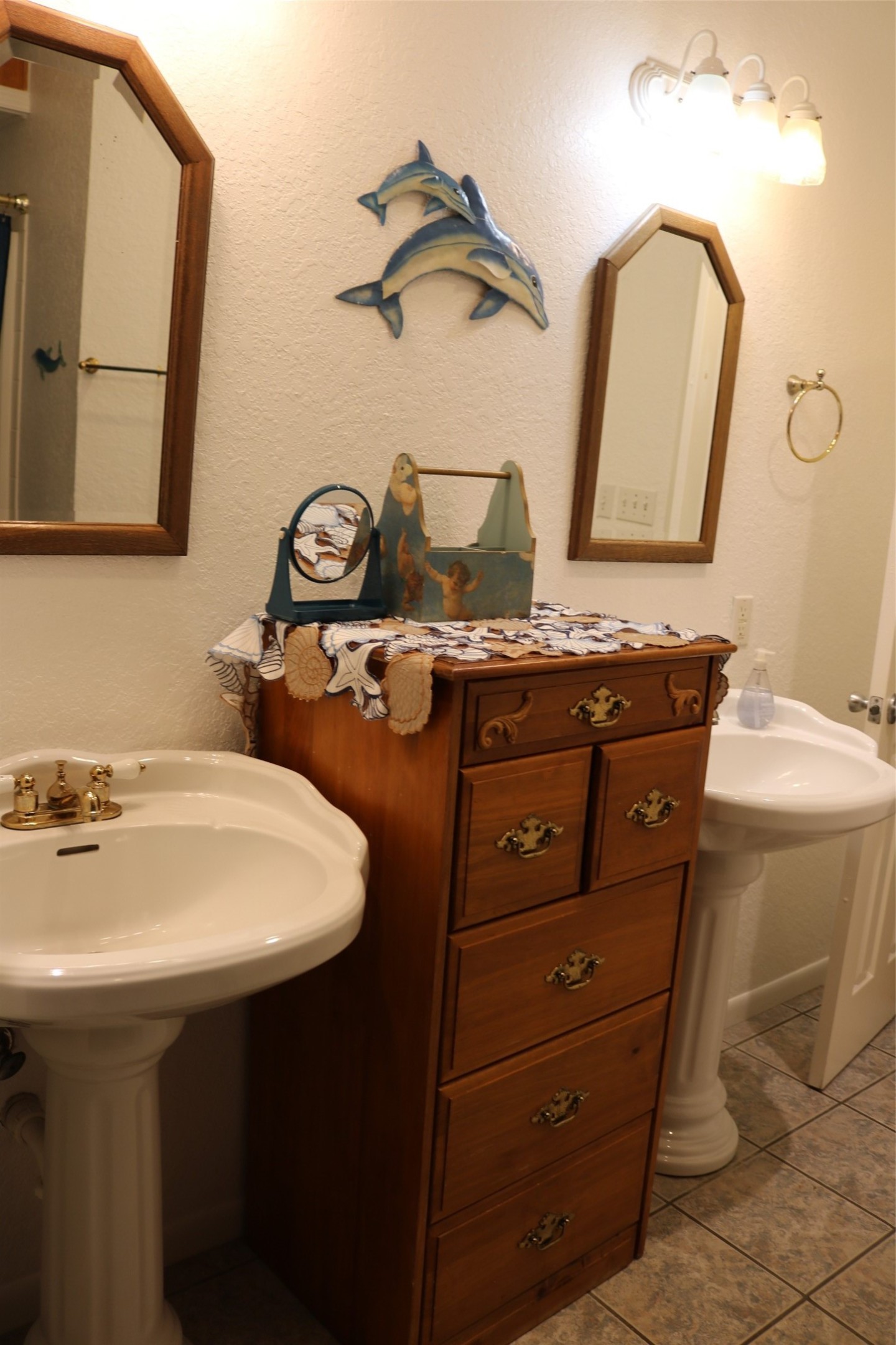 Maritime themed master bathroom featuring double sinks, a private toilet area, and a versatile bath/shower combination.