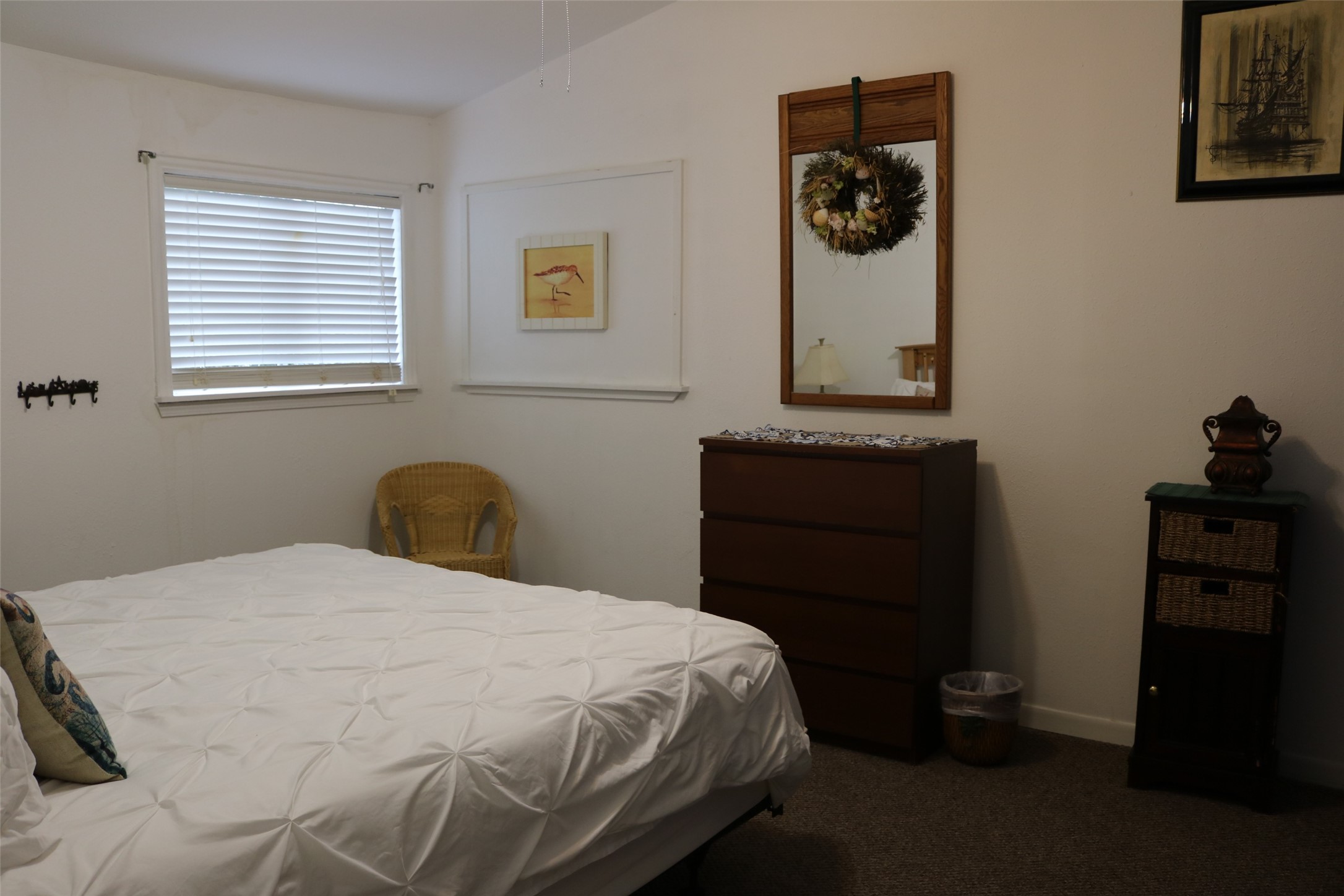 Spacious guest room featuring a comfortable king-size bed and sturdy dresser.
