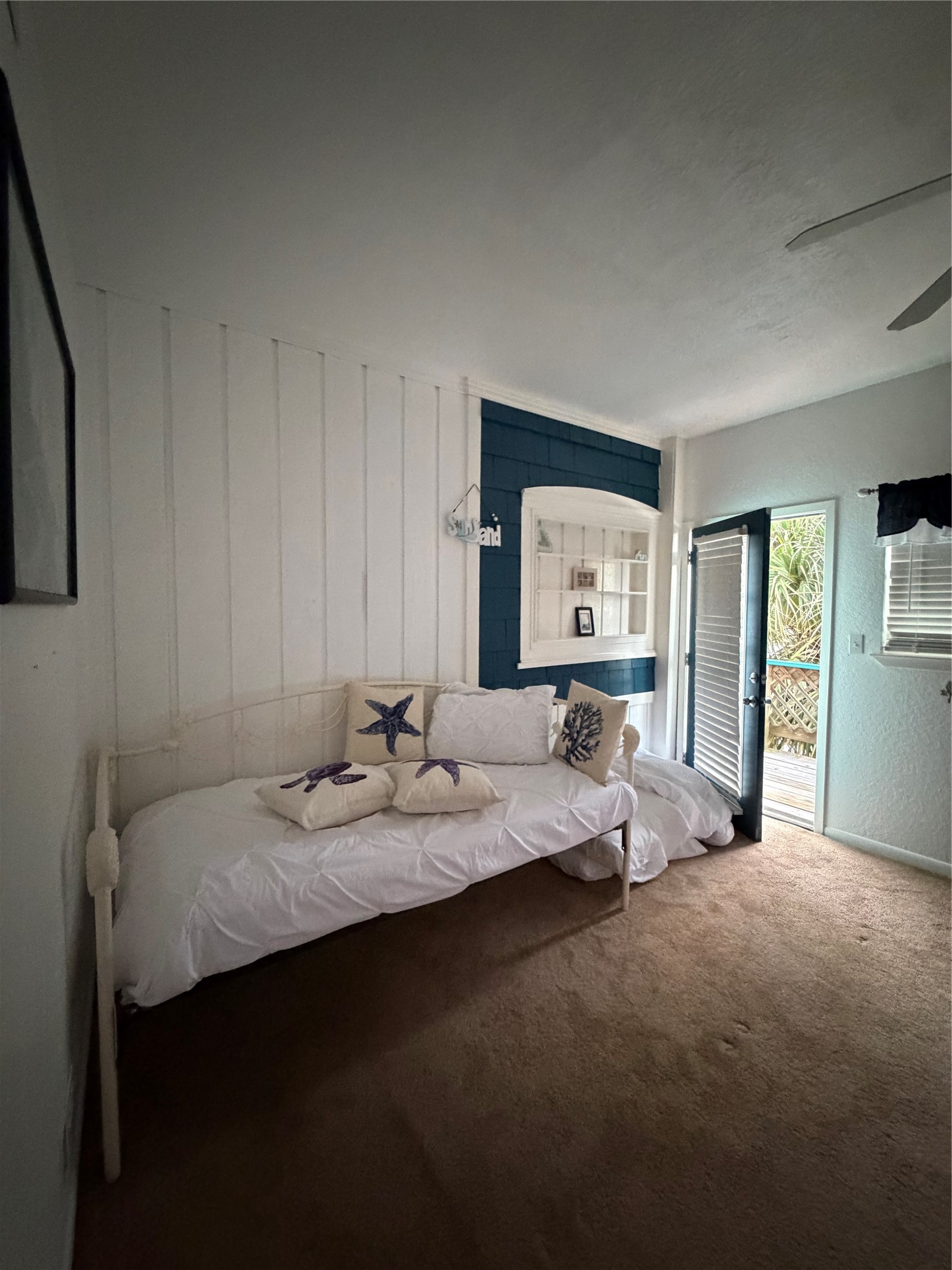Cozy daybed in the primary bedroom. A doorway that opens to an upper balcony with stunning bay views, perfect for sunset moments.
