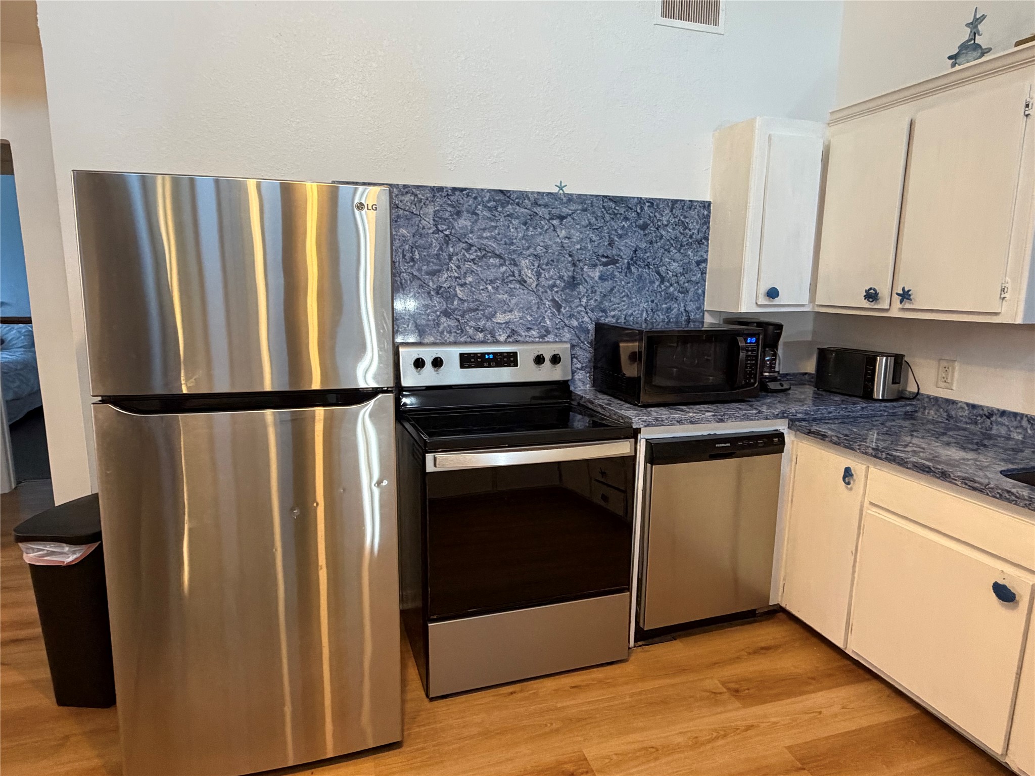 Modern kitchen with sleek freestanding refrigerator, stove, and dishwasher.