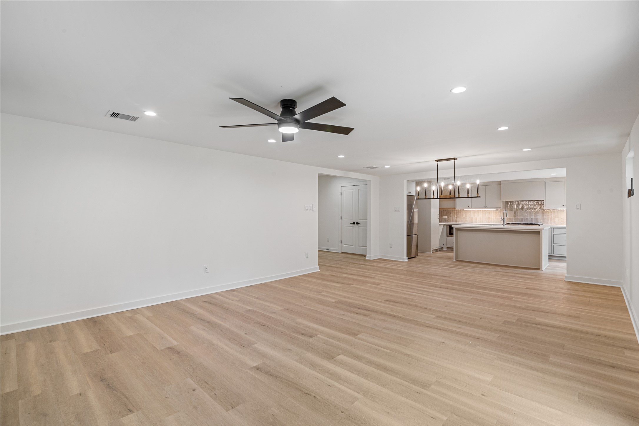 Wide view of the main living area showcasing the seamless connection to the renovated kitchen and dining spaces.