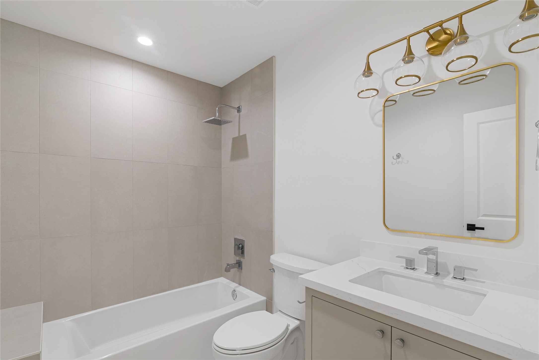 Additional view of the updated full bathroom showcasing the tub and shower combination, modern vanity, and decorative tile surround.