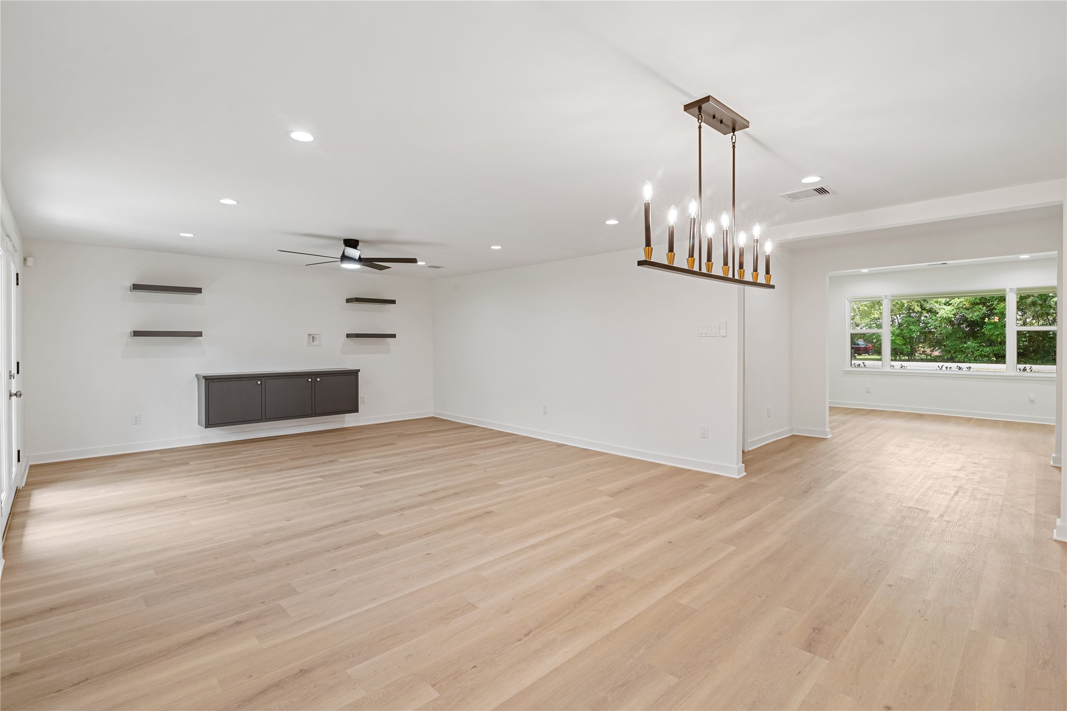 Spacious open-concept layout with contemporary lighting, abundant natural light, and flexible space for dining and entertaining.