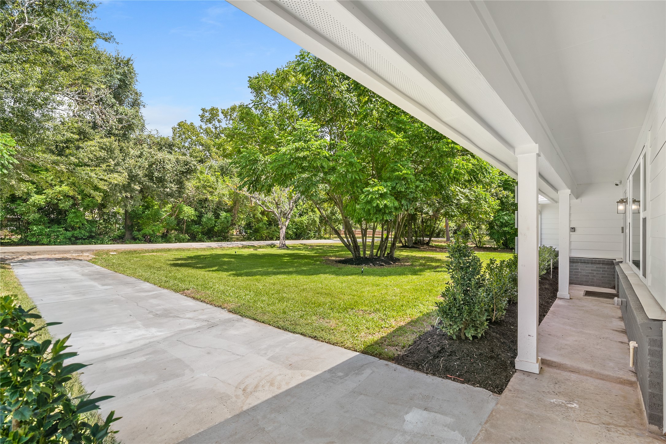 Covered area alongside the home offers a sheltered transition to the driveway and surrounding outdoor space.